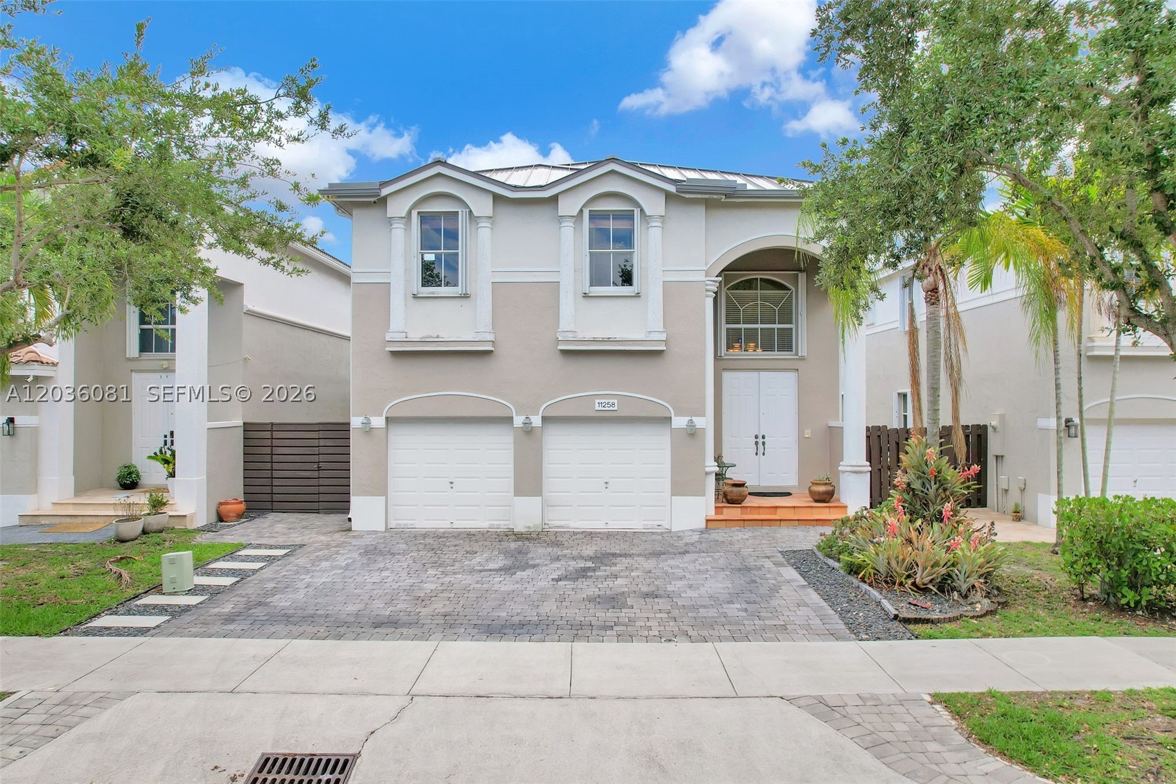 Meticulously maintained four-bedroom lakefront home in the gated Biarritz community in Doral, offering beautiful Miami sunset views and a functional layout with all bedrooms located upstairs for added privacy. Features include a metal roof with a 55+ year warranty, low maintenance fee, and a custom extended three-car paver driveway. The backyard is designed for entertaining with an illuminated elevated deck, jacuzzi, outdoor shower, fire pit, zen garden, and extended covered dining area, creating the ideal tropical setting for grilling, gatherings, or quiet evenings by the water.