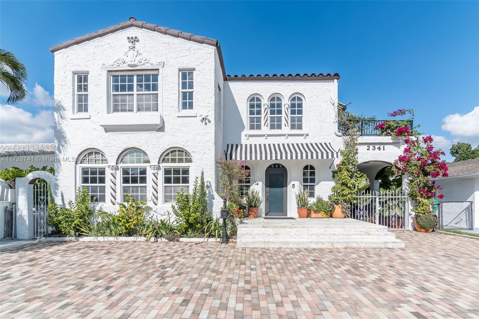 Step into this beautifully updated 100-year-old Spanish Revival home, just blocks from Shenandoah Park. With 27 custom impact windows, hand-painted wood beams, and a restored fireplace, this gem blends historic charm with modern luxury. Enjoy elegant arches, Dade County Pine, and terrazzo floors, paired with new AC units and LG smart appliances, including an AI-powered washer and dryer. Outside, a lush garden with fruit trees and two private terraces offer serene spaces to relax. The oversized master suite features a walk-in closet and motorized shades. A remodeled 1-bed, 1-bath detached cottage adds extra space and comfort. Classic beauty meets modern living in this one-of-a-kind home!