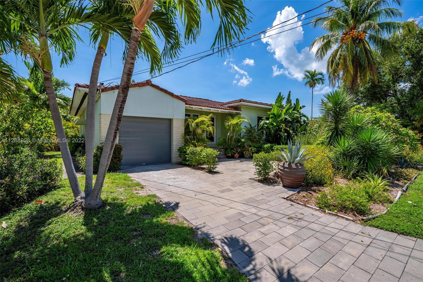 Charming house on an extra-large 6860 square foot corner lot in Surfside. The home has an appealing mix of original details and modern features, such as the original fireplace, warm wood floors, renovated kitchen, updated electrical, and hurricane impact windows/doors. There are 2 bedrooms, 2 bathrooms and a functional garage. Lush, native, low-maintenance landscaping has been added around the entire property, creating an inviting, tropical paradise. The huge, private backyard has plenty of space to add an addition or a pool and the oceanfront Surfside Community Center/Pool is just a few blocks away. Walk to the beach, shopping, dining, houses of worship, tennis courts, Four Seasons Surf Club & Bal Harbour Shops. Zoned for A-rated Bay Harbor k-8 school. Watch the virtual tour!