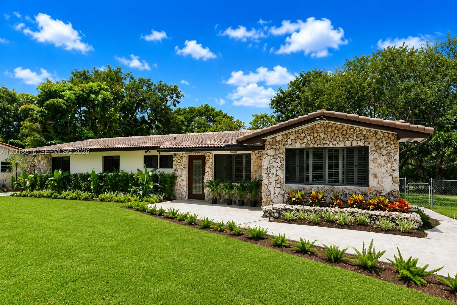 Showcasing the essence of classic South Florida architecture with tasteful modern updates, this substantially remodeled 5BD/3BA residence is defined by its rich use of natural keystone accents, timeless textures, and warm Miami-inspired design elements throughout. Situated on an oversized 15,400 SF lot in the desirable Sunset area of unincorporated Miami-Dade, the home offers abundant natural light and a flexible layout featuring a versatile 5th bedroom with private entrance, ideal for a guest suite, office, gym, or in-law quarters. The screened covered patio opens to an expansive backyard with ample space for a resort-style pool and summer kitchen, creating the perfect indoor-outdoor lifestyle. Backing directly onto the future Ludlam Trail linear park, the property enjoys the rare benefit of no rear neighbors, offering lasting privacy, greenery, and direct trail access from your own backyard. Additional highlights include a concrete tile roof, new A/C systems (2024), updated septic system, and brand-new landscaping with irrigation. Ideally located near top-rated schools, major highways, hospitals, and premier shopping and dining. Homes with this level of character, privacy, and lot size in the Sunset area are rarely available and highly sought after—schedule your private tour today before this exceptional opportunity is gone.