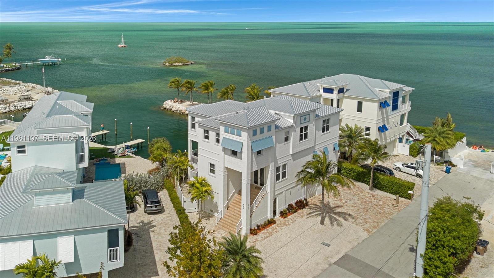 Experience exceptional waterfront living in this 2022 built home featuring 5 bedrooms and 4.5 bathrooms, perfectly positioned on the Gulf side with breathtaking water views. The main level offers a bright and open layout designed for both comfort and entertainment. A spacious modern kitchen showcases elegant cabinetry, quartz countertops with a striking waterfall edge, and premium stainless-steel appliances. Large dining and living areas, complete with a stylish wet bar, creating the perfect space for hosting and relaxing. This level also includes a convenient half bath and a utility room with laundry. Upstairs, the second-floor features five generously sized bedrooms and four full bathrooms. The expansive primary suite offers ample space, a beautifully designed modern bathroom, and a private porch where you can enjoy breathtaking sunset views over the water. Two additional bedrooms share a Jack-and-Jill bathroom and provide access to a balcony overlooking the pool and waterfront. A fourth bedroom, currently used as a home office, is located near another full hallway bathroom. The fifth bedroom is a private suite with its own ensuite bathroom. Featuring a large patio area ideal for entertaining, a spacious pool, and a 55-foot dock, making this property perfect for boating enthusiasts and waterfront relaxation. Additional highlights include a large two-car plus garage with ample storage space. Boat Lift plans have already been approved and permits granted and available.