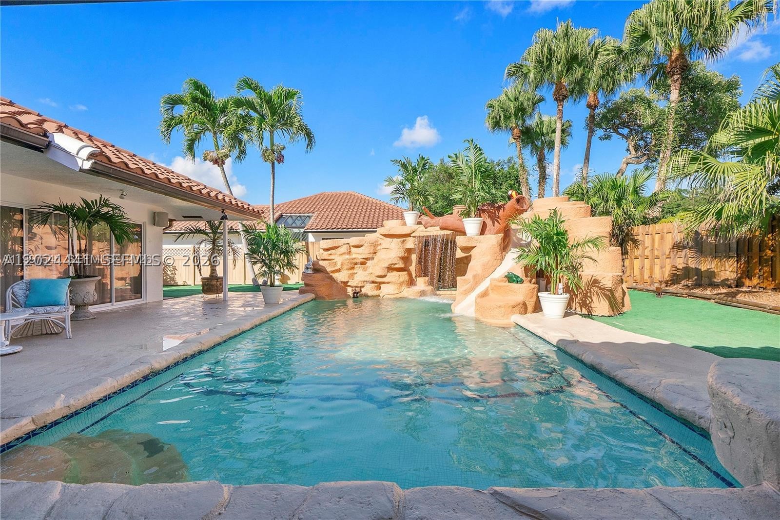 Exciting Resort style “Back Yard Water Park” with a thrilling kids water slide, and an amazing rock mountain cascading water wall and another huge waterfall that sounds like the ocean waves and a quite river stream, with huge palm trees covering the back yard. This renovated house has giant windows in every room giving massive picturesque lighting into every room. With a tennis court / pickle ball court, and a basketball court in addition to the back yard water park, this house is unbeatable. It’s only two blocks from the Town Center Mall, Publix, Walgreens and five of the top schools. This is your dream 3,000 sq ft "Open Concept Home Design” house with two huge Great Rooms with soaring ceilings and separate living/dining/family rooms. This fully remodeled open concept kitchen has new quartz countertops, and all new stainless steel appliances, stove, fridge, washer and dryer, including a huge food storage freezer hidden in the wall. The new bathrooms are absolutely beautiful, with a Jacuzzi jet tub in the master bedroom special white tile, new bathroom fixtures, and an great bright ceiling skylight.  All the appliances, water heater, pool equipment, and both air conditioning systems are all virtually brand new, along with completely renovated landscaped grounds and a maintenance free back yard with beautiful grass carpeting. All doors and windows will be Brand New Category 5 Hurricane Impact  in this home of your dreams that includes super low HOA fees.