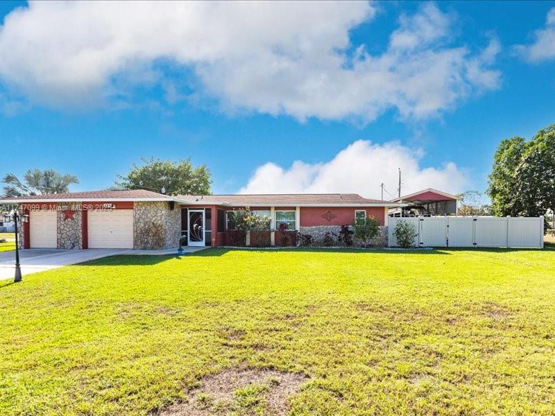 This 3-bed, 2-bath pool home NOT LOCATED IN FLOOD ZONE!!  NO HOA RESTRICTIONS. Fully fenced yard offering gated access to your covered boat/RV storage.  Large 700 SF screened lanai overlooking a salt-water screened-in pool, perfect for entertaining. Park in the full-size truck-friendly garage with attached golf cart parking. Perks include a generator hookup, solar panels and advanced security system. Just minutes to swing your club at the Lehigh Resort Golf Club, catch a game at the Red Sox Spring Training, or jump on a flight to anywhere in the world at The RSW International Airport. Find plenty of shopping and entertainment in downtown Fort Myers or enjoy a quick trip to the local boat ramp where you can take your boat to the Caloosahatchee River!