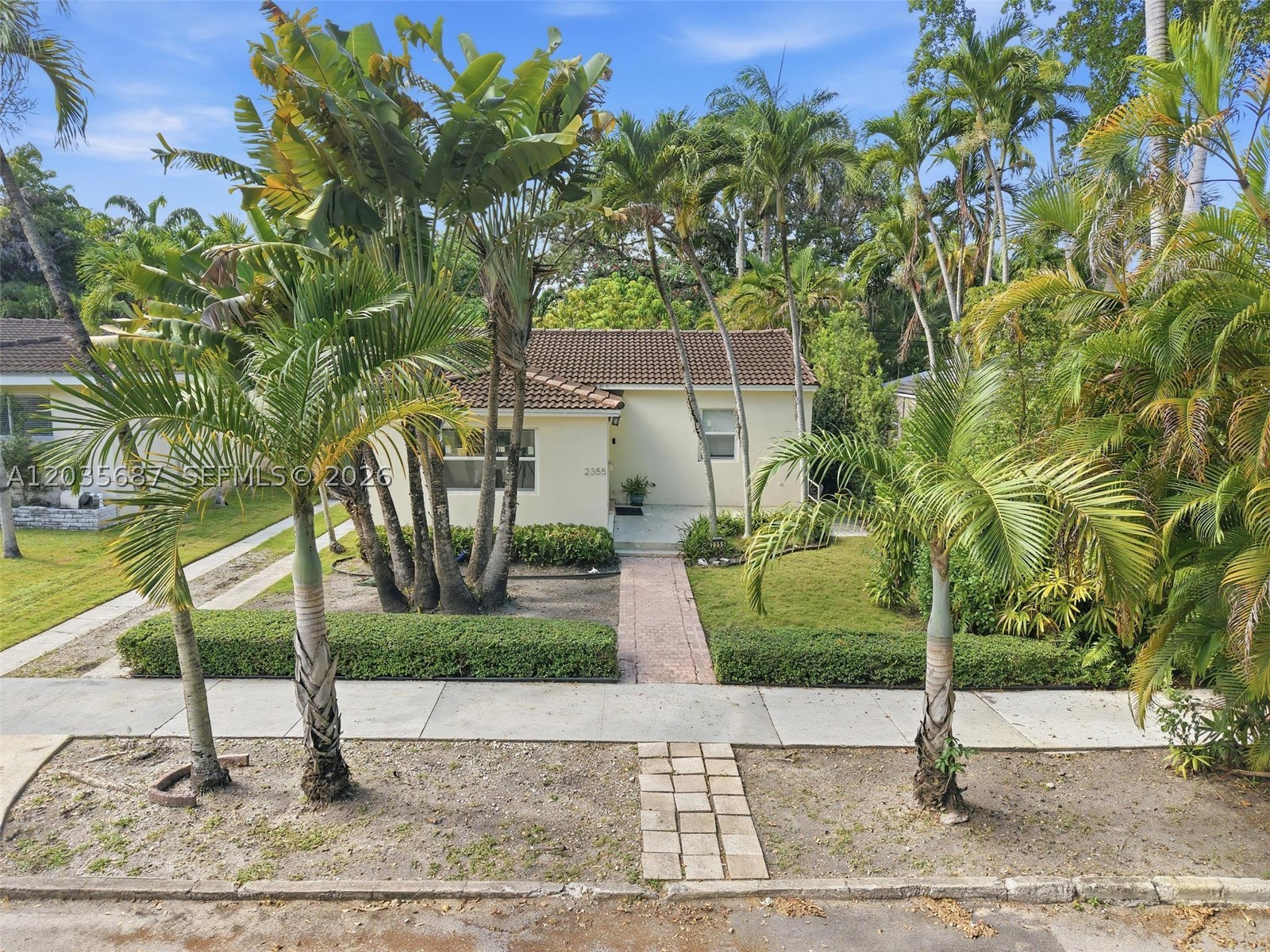 Tucked beneath the palm tree canopy on one of Miami’s beloved double-wide streets, this quintessential North Coconut Grove cottage blends Old Florida charm, history, and everyday convenience.
Built in 1947, 2355 Overbrook Street offers warmth and character on a generous, tree-shaded, high-elevation lot moments from the heart of the Grove and the Coconut Grove Sailing Club.
Inside, a light-filled, single-story floor plan features two bedrooms, one and a half baths, and a sunroom ideal for an office, reading nook, or flex space. The cottage-style bones are ready for your vision. Move in as-is or create the Grove renovation you have always imagined.

Much of the original Miami pine flooring remains, adding soul and authenticity. Recent updates include new HVHZ-rated hurricane impact windows and doors, updated stainless steel appliances, and a newer AC unit for comfort and peace of mind.

Outside, enjoy the true Grove lifestyle with quiet walkable streets, lush greenery, bay breezes, a nice backyard, and a genuine sense of community. Stroll to CocoWalk, Peacock Park, the bayfront, Coconut Grove Sailing Club, restaurants, cafés, boutiques, parks, and marinas.

Surrounded by new construction selling for $4.5M +this is a rare opportunity where land, location, lifestyle, and long-term upside come together. Top-rated schools, easy highway access, Brickell, and Downtown Miami are all close by.