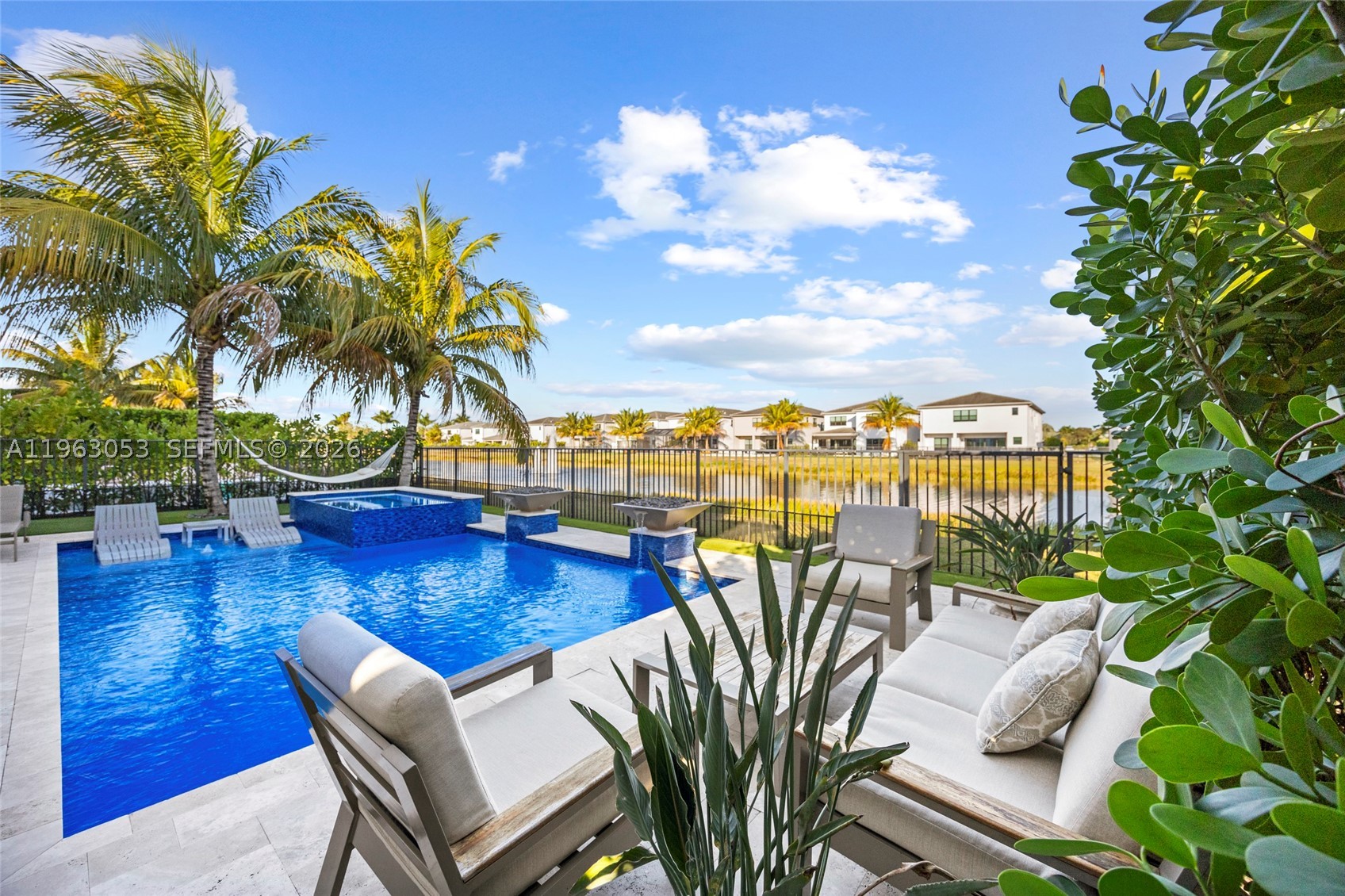Experience refined living in this stunning Polynesia model residence featuring 5 beds+media room (easily convertible into a 6th bed), 7 baths—including cabana bath and 4,484 sqft of meticulously designed space, with over $500,000 in premium upgrades and a fully curated interior design project throughout. The home showcases custom cabinetry upgrades across the main living areas, kitchen annex, bar area with wine cellar, pantry, media room, office, and walk-in closets. The chef’s kitchen is highlighted by a premium Sub-Zero refrigerator. A striking tempered glass staircase and railings enhance the modern aesthetic, while designer lighting and linen & blackout curtains create the perfect ambiance in every room. The private second-floor media room delivers a true cinematic experience. Step outside to a resort-style oasis designed for both entertaining and relaxation: gas heated pool and spa, fire pit with cascading waterfall, travertine flooring, and a fully equipped summer kitchen with 2 grills, refrigerator, and a dedicated zero-degree beverage cooler. A solar-powered automated pergola and professionally designed landscaping with lighting and low-maintenance synthetic grass complete outdoor experience. House offers exceptional privacy with no home in front, plus a beautiful backyard lake with views of the fountain. Residents enjoy exclusive access to a 26,000 sqft resortstyle clubhouse.A seamless blend of luxury, design, and lifestyle—this is Boca Raton living at its finest.