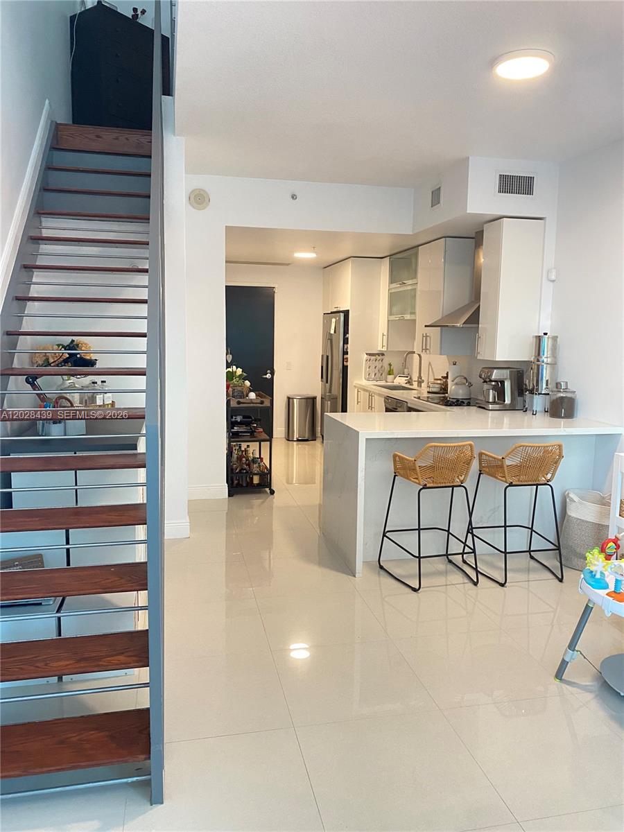 Experience elevated Brickell living in this beautifully updated loft residence at Infinity at Brickell. This bright and spacious 1-bedroom, 1.5-bath home features soaring double-height ceilings, floor-to-ceiling impact glass, and a highly desirable open loft layout filled with natural light. The renovated kitchen showcases modern cabinetry, marble countertops, stainless steel appliances, and a breakfast bar that opens seamlessly to the living area, creating the perfect space for everyday living and entertaining.

Both bathrooms have been tastefully remodeled with contemporary finishes. Additional improvements include a newer A/C system and brand new dishwasher.

The upper-level loft bedroom features a renovated en-suite bath and generous walk-in closet. Enjoy city, skyline, and pool views from the private balcony. Additional features include an in-unit washer and dryer and one assigned parking space.

Infinity at Brickell offers resort-style amenities including a pool, fitness center, spa, club room, concierge, valet, and 24-hour security. Ideally located just steps from Brickell City Centre, Mary Brickell Village, premier dining, shopping, entertainment, MetroMover, and Metrorail.