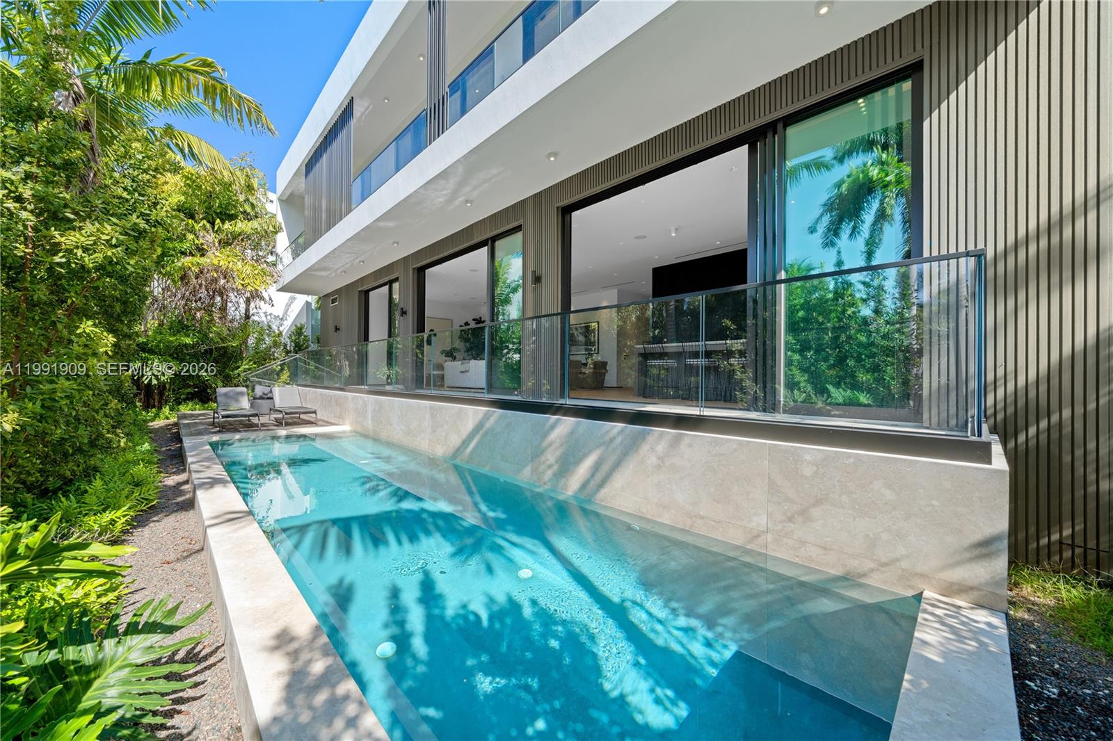 Brand-new architectural masterpiece on the exclusive, guard-gated Palm Island. This stunning 4-bedroom, 4.5-bath residence offers 3,077 square feet of modern luxury with an open-concept layout, custom Italian kitchen and closets, seamless indoor-outdoor living, and a sleek contemporary pool surrounded by lush tropical landscaping. A 370-square-foot rooftop terrace delivers breathtaking water, skyline, and sunset views. Palm Island offers 24/7 Miami Beach police security, gated entry, tennis and basketball courts, and a children’s playground. Conveniently situated just minutes from MIA Airport and the best dining and social scenes in South Beach, the Design District, and Downtown.