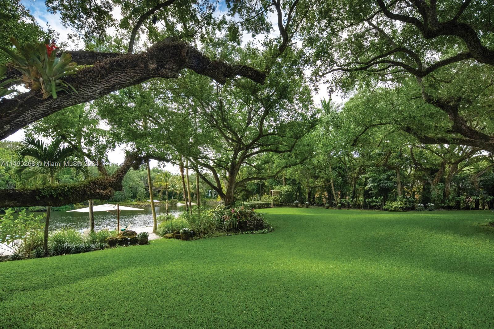 Sprawling 11,734 total SF lakefront estate in the prestigious guard-gated community of Snapper Creek, with
unparalleled luxury and 5-BD, 5-BA and 2-HB. Over 1.5 lushly landscaped acres, with 313 trees, a private beach
and 2 fire pits. Infinity saltwater pool and waterfall custom designed to color-match the lake; bougainvillea covered dining pergola with summer kitchen and pizza oven. Floor-to-ceiling windows and doors flood the spacious traditional floor plan with natural light, perfect for an art collection. The custom designed library and kitchen includes an exquisite, oversized island with top-of-the-line luxury appliances, perfect for entertainment. Enjoy peace of mind
with a water purifying system, whole house generator, impact windows/doors, and a 10 year assignable roof warranty.