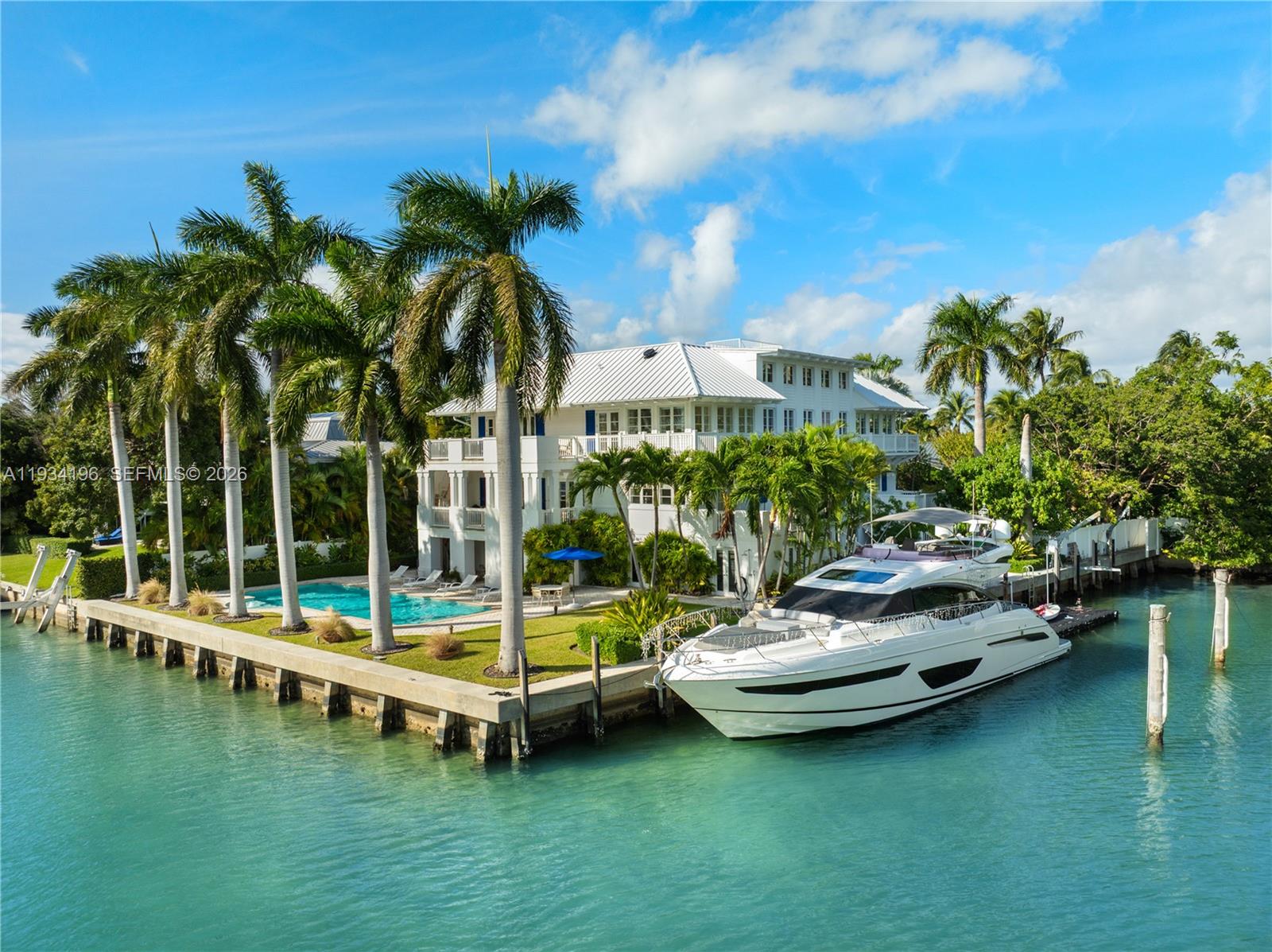 Enjoying an exceptional 270ft of L-shaped water frontage facing 185-ft-wide Pines Canal and the natural beauty of Bill Baggs Cape Florida State Park, this elegant island-coastal estate is tailored to a boating lifestyle. Offering calm and naturally sheltered harbor, concrete seawall, boat lift, dockside kitchen and side-dock boat storage that preserves unobstructed water views, the property provides a sense of openness, privacy, and tranquility. 

Clean architectural lines, an internal garden courtyard, and generous covered terraces fill the residence with natural light and create a seamless connection to the surrounding water and landscape. This elevated home offers 4 bedrooms plus staff quarters, 5 bathrooms, and 4 half-baths within 8,240 sqft of living space on a 16,500-sqft lot.

Architectural tray ceilings, refined millwork, custom wall paneling, and thoughtfully designed built-ins with abundant storage add depth and craftsmanship while maintaining a light, contemporary coastal aesthetic. Formal living and dining rooms with elegant millwork provide an ideal setting for entertaining. The kitchen is appointed with Calacatta Gold marble countertops, gas cooking, Sub-Zero and Viking appliances, and a butler’s pantry. Additional highlights include 2 family rooms, fitness center with water views, 2 garages accommodating 7+ cars/golf carts, temperature-controlled wine cellar for 1,400+ bottles, elevator, retractable screen doors, generator and saltwater heated pool.