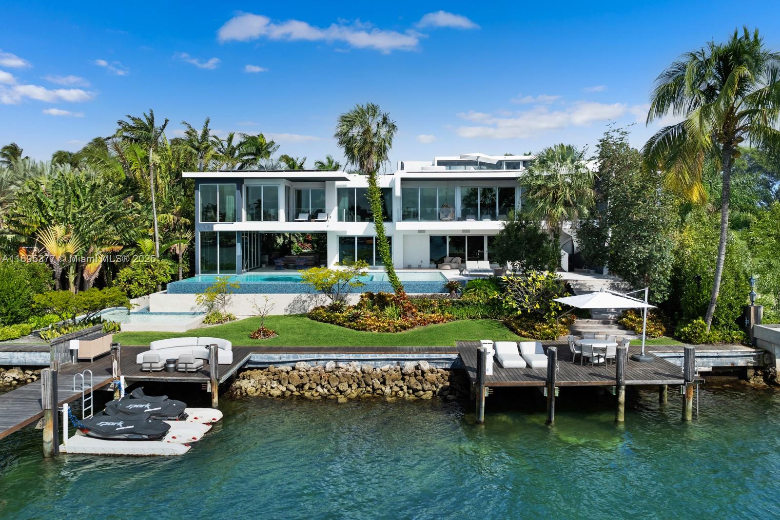 Welcome to this contemporary marvel on prestigious guard-gated Hibiscus Island, designed by architect Reinaldo Borges & famed landscape artist Raymond Jungles! Perfectly positioned on a 1/2 acre double lot w/122' of prime WF & breathtaking skyline views, this estate truly blurs the line of indoor/outdoor living. Soaring ceilings & a masterfully curated floorplan showcase 5 grand bedrooms, 5.5 baths, & exquisite entertaining spaces throughout. The gourmet kitchen, equipped w/high-end appliances, flows seamlessly into the elegant dining area. The lavish primary suite features dual bathrooms & closets, ensuite office, & private terrace w/sweeping views. Unrivaled amenities include Crestron home system, elevator, sauna, Bowers/Wilkins cinema, rooftop terrace, whole home generator & more!