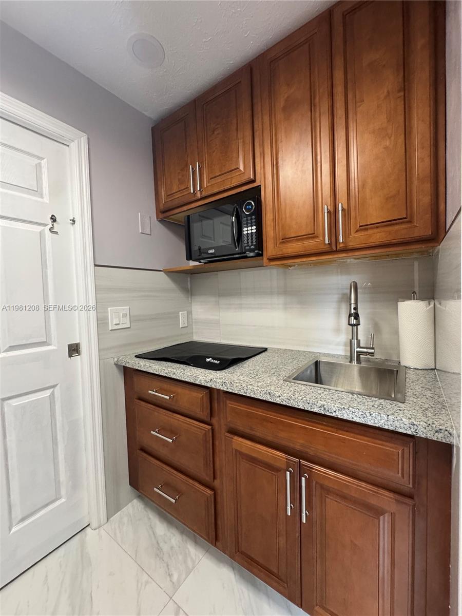Well-maintained efficiency. The unit features a bright living and sleeping area, updated flooring, and a clean, modern bathroom with a glass-enclosed shower and contemporary vanity. The kitchenette area includes cabinet storage, countertop space, and a cooktop, providing everything needed for everyday living. The space is thoughtfully designed to maximize comfort while maintaining a clean and modern look.

All utilities are included in the rent, including water, electricity, and internet, making budgeting simple and hassle-free. The property is well kept and located in a convenient Lauderdale Lakes location with easy access to major roads, shopping, dining, and everyday services.