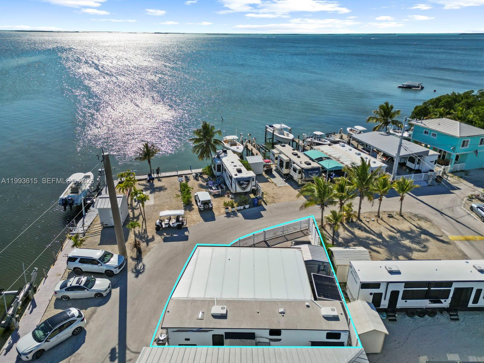 Oversized corner lot in Calusa Campground offering ~1,000 sq ft more than standard lots with partial bay and canal views. Enjoy the convenience of an assigned boat slip with 15,000 lb lift located directly across the street, making this a true boater’s retreat.

This fully paved and fenced property is designed for easy Keys living and entertaining, featuring a covered awning with lighting and screening and a beautiful outdoor kitchen.

Additional upgrades include a private shed with extra storage, refrigerator, and full-size washer/dryer—a rare and valuable feature in the community.

Property includes a 2022 Forest River Salem Grand Villa 42FK destination trailer with approximately 360+ sq ft plus slide-outs, offering a private primary bedroom, spacious loft sleeping area, and open living/kitchen layout, ideal for personal use or rental potential.

Owner financing available with 30% down, 10-year term, and a rate below 10%.