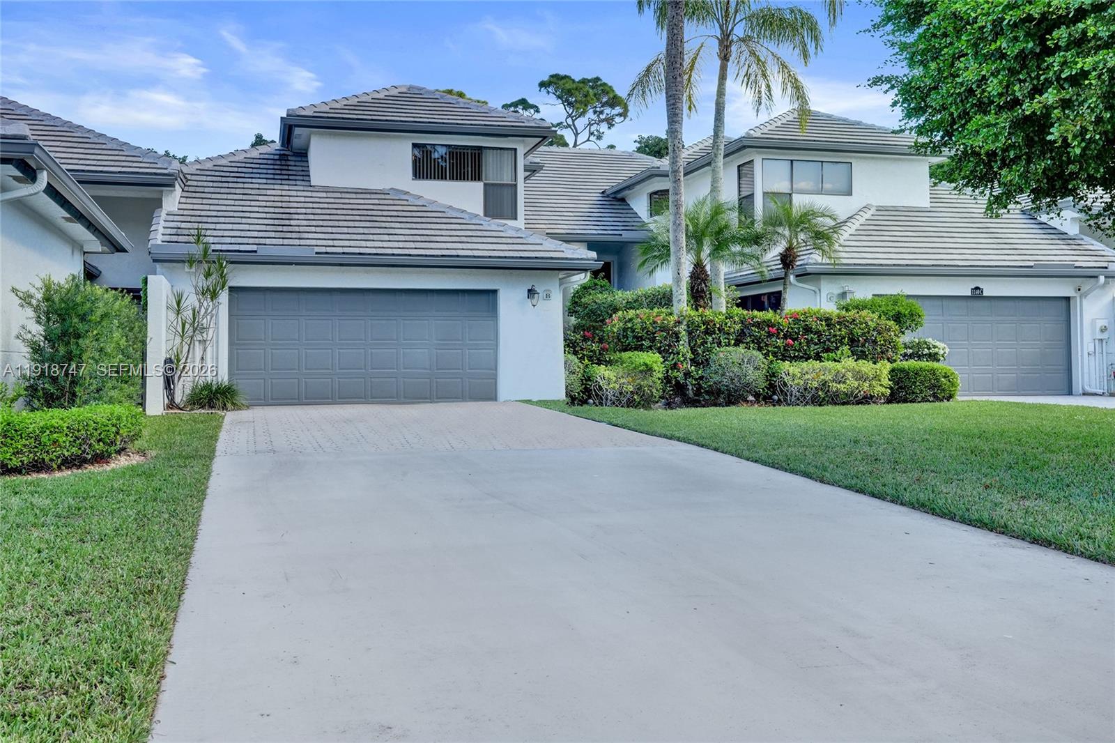 MAKE IT YOUR OWN — PRICED FOR UPDATES! Opportunity to own in the highly sought-after Sand Drift Villas of Breakers West at one of the lowest price points in the community. This three-bedroom, two-and-a-half-bath townhome offers a solid layout with soaring volume ceilings, a wood-burning fireplace, built-in wall unit, and a desirable first-floor primary suite. The kitchen is already updated with off-white cabinetry, stainless steel appliances, wood-plank tile flooring, and an eat-in area. Upstairs, two spacious bedrooms share a fully updated bath, with one bedroom featuring a private rooftop deck. Enjoy a large screened-in patio with sink, cabinetry, and TV — perfect for indoor-outdoor living. Carpet throughout living areas and bedrooms and bathrooms in the primary suite are ready for your personal updates, offering the perfect opportunity to customize and build equity. Two-car garage with extended driveway. Major components: 2023 roof, 2017 A/C (regularly serviced), newer washer and refrigerator. Located in a manned, guard-gated community with optional club memberships. Convenient to West Palm Beach Airport, dining, and entertainment. Gated community – no signage permitted, GPS required.