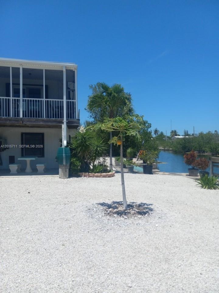 Experience the laid-back Florida Keys lifestyle in this beautifully maintained, double lot sized at 12,000 sq ft, concrete 2-bedroom, 2-bath stilt home located on a desirable clean swim canal in Big Pine Key. Situated at the end of the street with no through traffic, this secluded waterfront retreat offers exceptional privacy, tropical breezes, and the perfect blend of comfort and coastal living.

The home sits on an ideal east-west exposure, allowing for a refreshing cross breeze throughout the property and abundant natural light from the many windows throughout the home. Step inside to discover a nicely finished interior featuring laminate flooring, granite countertops, and soft close cabinets, a spacious living and dining room area, and huge walk-in closets that provide excellent storage space. Offered fully furnished, this home is move-in ready and ideal as a full-time residence, vacation getaway, or investment opportunity.

Outdoor living is truly exceptional with two large screened decks that enhance the outdoor living space, perfect for relaxing, entertaining, or enjoying peaceful canal views and tropical surroundings. Enjoy looking at the many fruit trees on the property including, papaya, mangos, dragonfruit, 2 varieties of bananas, grapefruit, lemon, Spanish limes, melon, and pineapples.  The property also offers plenty of room for a pool, gazebo, or garden area, creating additional potential for your private island oasis.