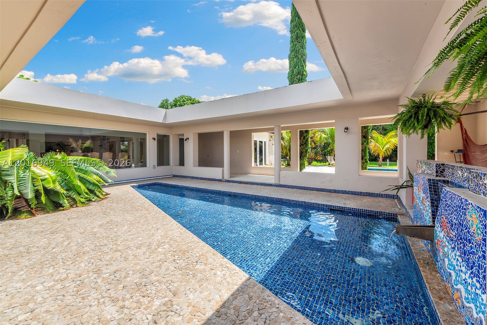 An iconic mid-century modern masterpiece by legendary architect Kenneth Treister, this one-of-a-kind 6-bedroom + den/office, 6-bath estate is a true living work of art in the heart of Pinecrest. Completely walled and gated, the property offers exceptional privacy and security across a sprawling 33,000 SF lot. The home showcases Treister’s signature architecture with soaring wood ceilings, walls of glass, sculptural details, striking water features, and a seamless connection to the lush tropical surroundings. Recently renovated with high-end finishes, the home features a stunning chef’s kitchen, impact glass throughout, expansive entertaining spaces, a resort-style pool, outdoor Chicago brick fireplace, and a massive 2.5-car garage. Bold, artistic, and completely unforgettable.