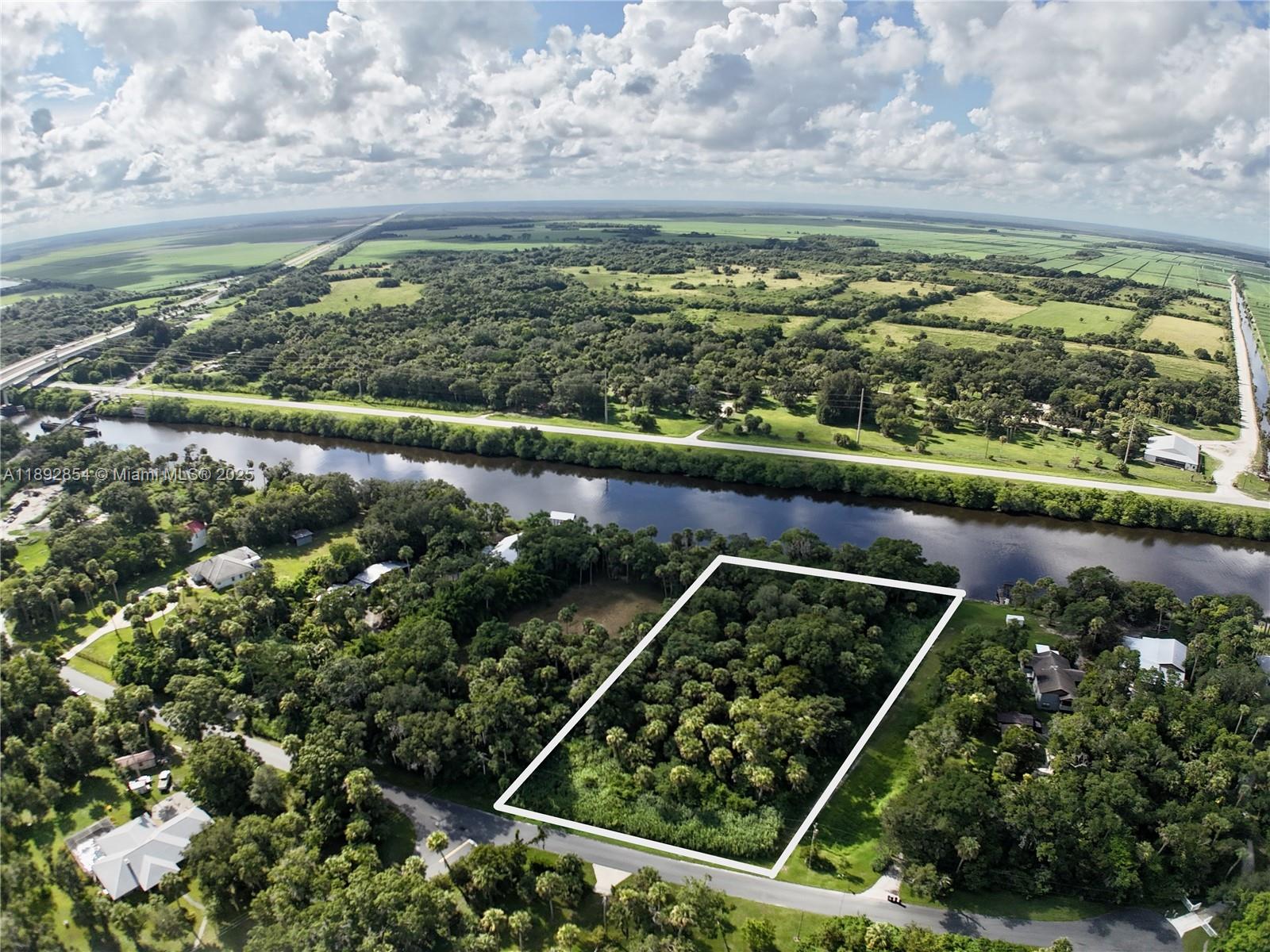 Exclusively Presented by Sunland Real Estate: Under a canopy of old-Florida oaks, this 1.97-acre waterfront homesite in Palm Oaks (Village of Indiantown) offers direct frontage on the St. Lucie Canal/Okeechobee Waterway—a rare blend of privacy, space, and navigable water access. Build your private estate with room for a residence, shop/barn, toys, and gardens, all on a quiet paved street just minutes to Indiantown’s shops, dining, parks, and boat ramps. Quick routes to Stuart/Palm City via SR-710 & US-441/98, yet a peaceful rural vibe in Martin County.