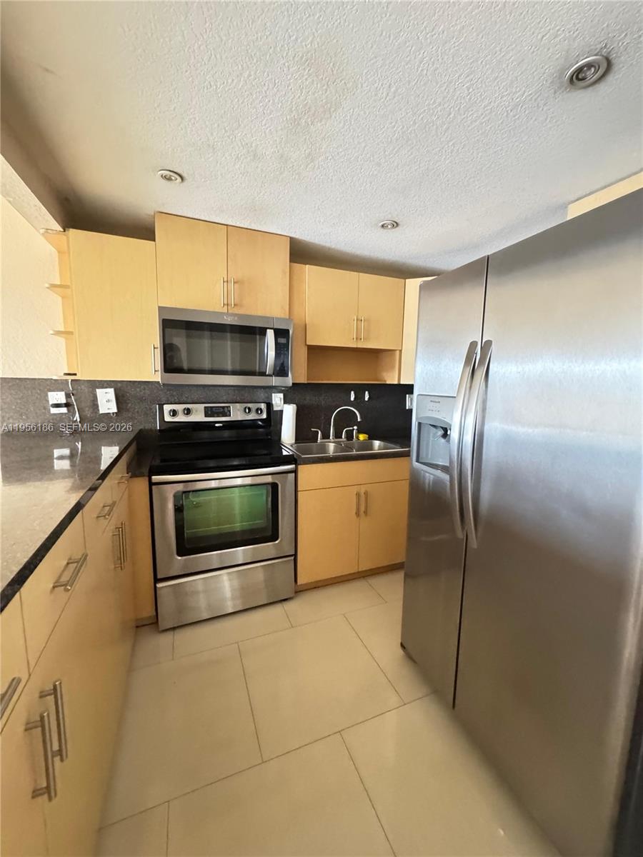 Beautiful and bright 2-bedroom, 1 bath condo featuring elegant white ceramic floors throughout and a modern kitchen with sleek cabinetry and stainless-steel appliances. This spacious unit offers plenty of natural light, creating a warm and inviting atmosphere. Conveniently and centrally located near major highways, shopping centers, restaurants, and entertainment. The building offers great amenities and a comfortable lifestyle. Move-in ready and perfect for those seeking style, comfort, and convenience!