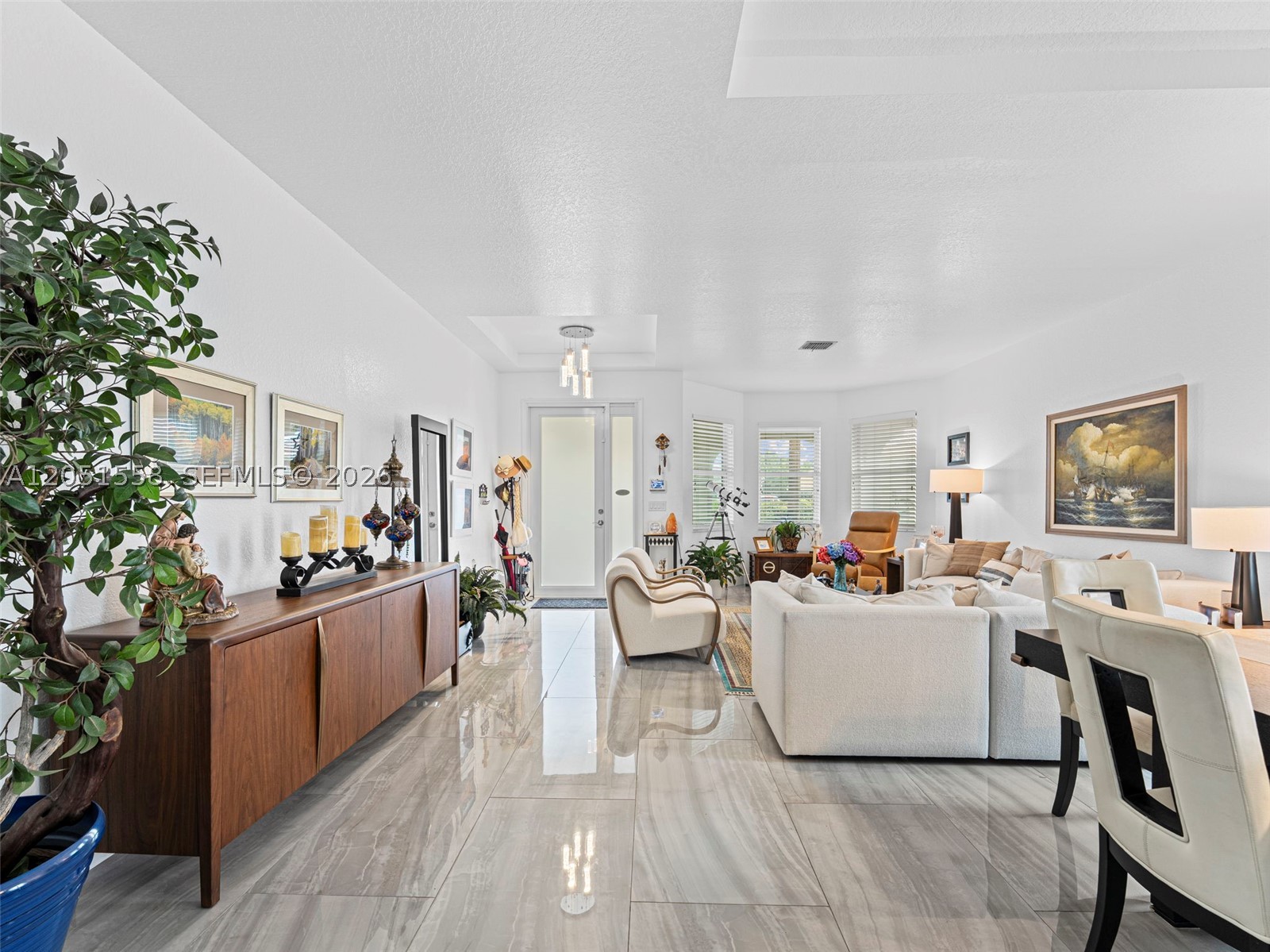 Experience refined living in this impeccably maintained residence. Thoughtfully designed with 4 bedrooms, 2 bathrooms, and 2,275 square feet of sophisticated living space, this exceptional home sits on a sprawling 11,380-square-foot lot. From the moment you enter, you’ll appreciate the soaring tray ceilings, oversized porcelain tile flooring, and a bright, open layout complemented by elegant formal living and dining areas. The chef-inspired kitchen showcases sleek contemporary cabinetry, stone countertops, stainless steel appliances, a designer backsplash, and an oversized island overlooking the spacious family room, ideal for everyday living and effortless entertaining. The private primary suite is a true retreat with direct pool access, a spa-inspired bath featuring dual vanities, a soaking tub, separate shower, and a custom walk-in closet. Step outside to your own resort-style oasis featuring a freeform pool, expansive brick paver patio, covered seating area, and an oversized, fully fenced backyard framed by mature tropical landscaping for exceptional privacy. Additional highlights include generously sized secondary bedrooms, one staged as a home office, and a versatile garage thoughtfully designed with a dedicated workout area and separate storage space. Located within a desirable gated community offering a clubhouse, pool, fitness center, basketball courts, and tennis courts, this exceptional home offers luxury, comfort, and the best of South Florida living.