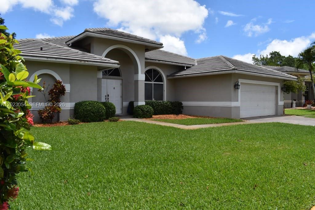 Beautifully updated OPEN PLAN home with modern updates for the bathrooms, kitchen, cabinets, counters, and appliances. Once you walk in, you are greeted with the open expanse. Taverntine tiles and wooden flooring complete the look.  The Banded Zebra window treatments provide an elegant, modern finish to the living areas, overlooking a well-fruited fenced garden with a shaded terrace. Eat off the land - avocados, coconuts, citrus, and space for a vegetable garden. Comes with a shed as well. The dining area is off the kitchen, which has a huge island that can seat 8-10 easily. Updated cabinetry, countertops, and stainless steel appliances, even includes a wine cooler. The laundry room is under air and has an extra kitchen pantry. The Primary suite has two (2) walk-in closets as you head towards the bathroom, which has two split sinks and an updated shower stall with a rain shower head. The other two sizable bedrooms are on the other side and share an updated modern bathroom.  The home has a complete set of hurricane shutters.  The HOA is low and the development is centrally located.  Easy access to shopping, dining, schools, and the highway.