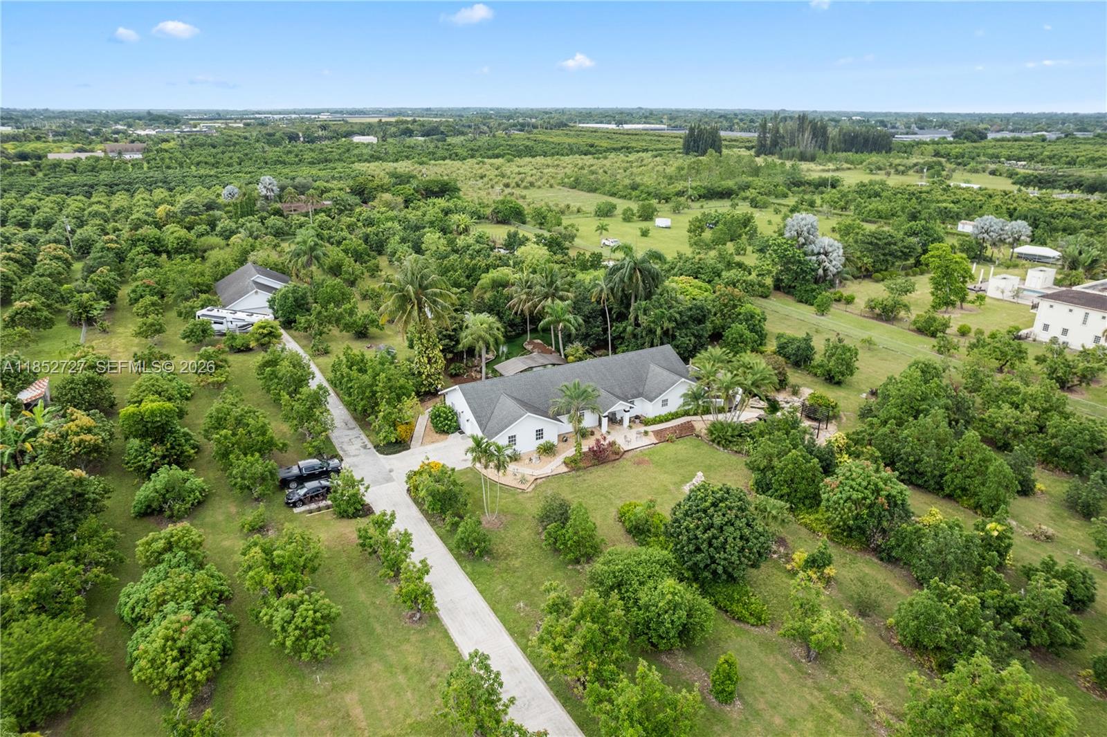 Tropical paradise in the heart of the Redlands. This rare 5-acre agricultural estate offers two homes, lush grounds, and tranquil water features that create a true private retreat. The main residence features 3 bedrooms, 2.5 baths, a 2-car garage, with updated kitchen and bathrooms.  A separate 2-bedroom, 2-bath guest home with its own 2-car garage is ideal for multigenerational living or rental income. Meandering ponds set the tone for relaxation, including an oversized koi pond easily convertible to a swimming pool, all enjoyed from a shaded gazebo and tiki bar. The property is enriched with a variety of fruit trees and fully fenced for privacy. Additional features include RV parking with 50-amp hookup, barn, sheds, and chicken coop. A unique opportunity to own a serene tropical oasis with space, versatility, and income potential.