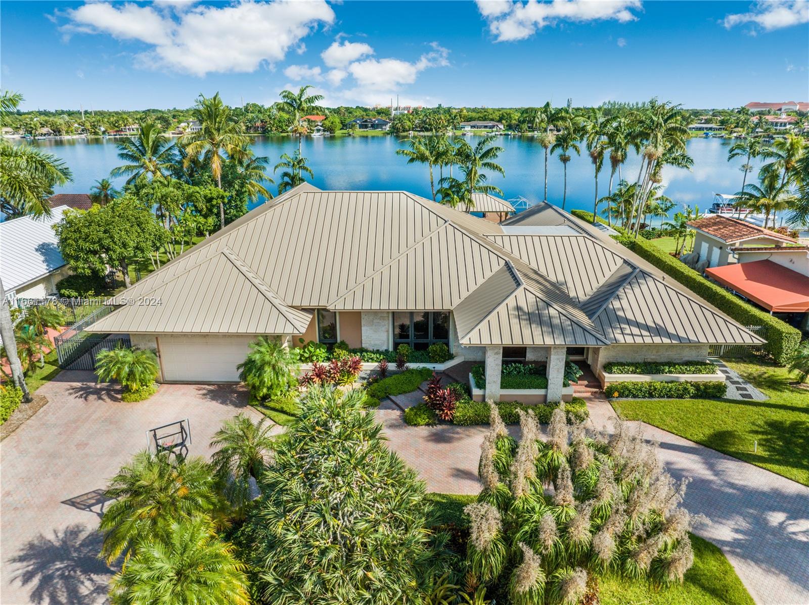 Paradise Found! Experience luxury living on the pristine shores of E Lake, home to only 116 exclusive residences. This stunning property offers breathtaking wide lake views, featuring 4 spacious bedrooms, 3.5 baths, and a separate guest house. The home boasts soaring oak ceilings, a brand-new metal roof, impact windows and doors, high end appliances, and sleek electric blinds for modern convenience. Step outside to your own private beach, relax by the fabulous pool and expansive patio, or enjoy your amazing dock with boat and jet ski lifts—perfect for boating, waterskiing, and endless lakefront activities. This home truly has it all!