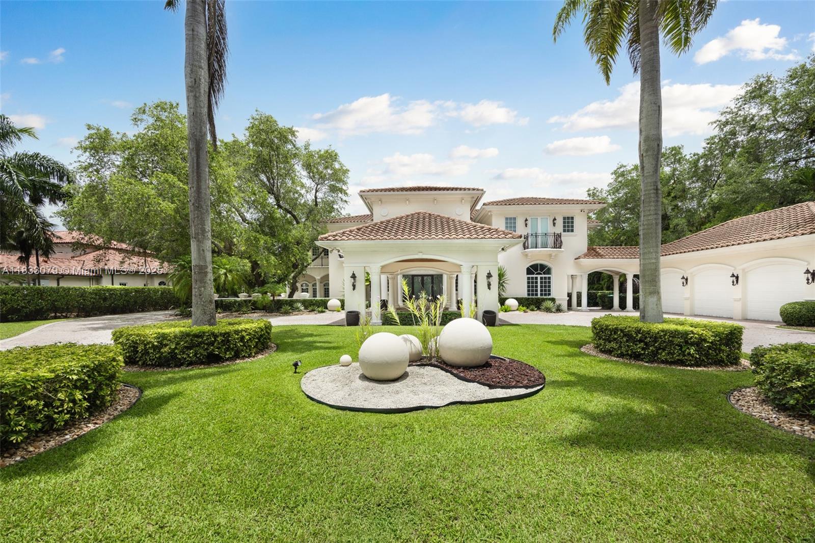 Set on over an acre in lush Pinecrest, this grand two-story estate offers 7 bedrooms and 6.5 bathrooms, including a detached guest house with shared cabana bath. A dramatic foyer introduces formal living and dining rooms divided by a double-facing fireplace. The chef’s kitchen is equipped with Monogram appliances, double ovens, and a central dining space, flowing into the family room and outdoor terraces. With a 13-seat theater, billiard room, and summer kitchen with built-in grill, the home is designed for effortless, year-round entertaining. Additional highlights include a library with custom built-ins, elevator, whole-house generator, and detached 3-car garage. Outside, enjoy a resort-style saltwater pool with grotto and spa, featuring a flexible chlorination system.