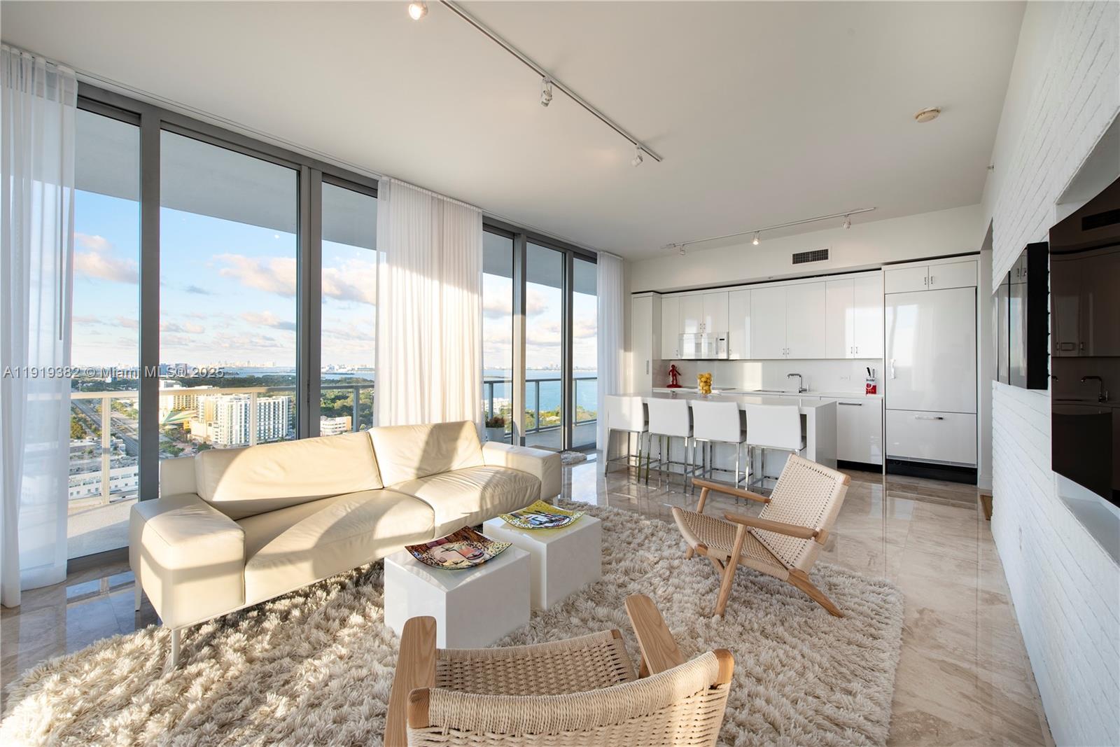 Experience luxury living at 2Midtown, where breathtaking sunsets and bay views set the stage for your day. This fully renovated 2-bedroom plus den (easily convertible to a 3rd bedroom) residence blends modern elegance with thoughtful design in every detail. Step inside to find marble flooring throughout, a custom kitchen complete with a spacious island, Miele appliances, and sleek quartz countertops. Chic brick accent walls add warmth and style, while soaring 10-foot ceilings and an oversized terrace with glass railings invite you to enjoy Miami’s indoor-outdoor lifestyle. 
The primary suite is your private retreat, featuring built-in storage, a generous walk-in closet, and an en-suite bath designed for ultimate comfort and functionality. A large guest suite features a spacious walk-in closet. A versatile den offers flexibility as a home office, creative studio, or can be converted to a guest bedroom with direct access to the terrace and a bathroom.
At 2Midtown, luxury extends far beyond your front door. Residents enjoy access to a full suite of amenities, including a state-of-the-art fitness center, resort-style pool, steam room, sauna, doorman and concierge services.
Located at the crossroads of Miami’s most exciting neighborhoods, this home puts you steps away from the vibrant Wynwood Arts District, the Miami Design District, and everything Midtown has to offer. From world-class shopping to award-winning dining and cultural experiences, it’s all just outside your door.