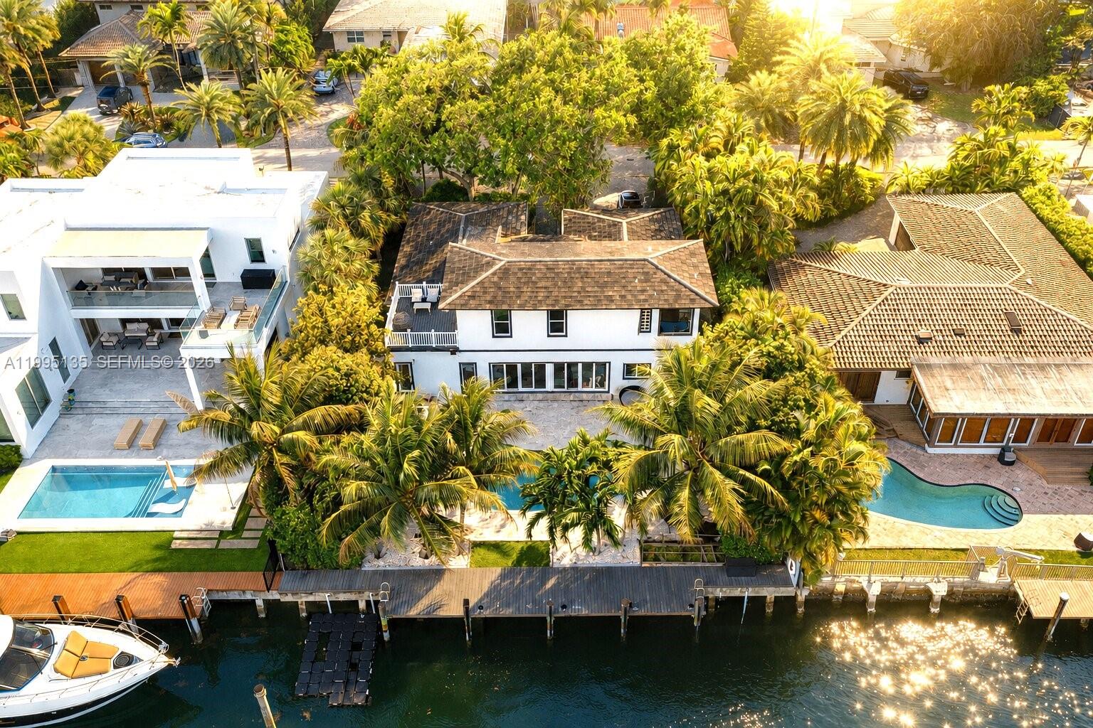 Nestled in the prestigious guard-gated community of Sans Souci Estates, this modern and two-story waterfront residence offers direct ocean access with no fixed bridges, an exceptional opportunity for boating enthusiasts.

This elegant home features 5 bedrooms and 4 bathrooms, including two spacious primary suites thoughtfully positioned on each level for ultimate flexibility and comfort. The interiors are finished with high-end black porcelain plank flooring and a sleek kitchen, blending modern design with everyday functionality.

Expansive impact windows and doors fill the home with natural light while ensuring peace of mind. Recent upgrades include a 2017 roof, 2019 dock, and a recent sea wall. The 3-zone A/C system, offers efficiency.

Outdoor living is designed for both relaxation and entertaining, with a beautifully landscaped setting, a large natural stone patio, and a saltwater pool overlooking the water, perfect for enjoying Miami’s year-round sunshine. The private dock provides effortless access to the bay and ocean within minutes, ideal for seamless day-to-day boating.

Ideally located just moments from Bal Harbour, beaches, fine dining, and luxury shopping, with convenient access to major highways.

A rare turnkey waterfront property in one of Miami’s most desirable gated communities, offering privacy, security, and the ultimate South Florida lifestyle.
