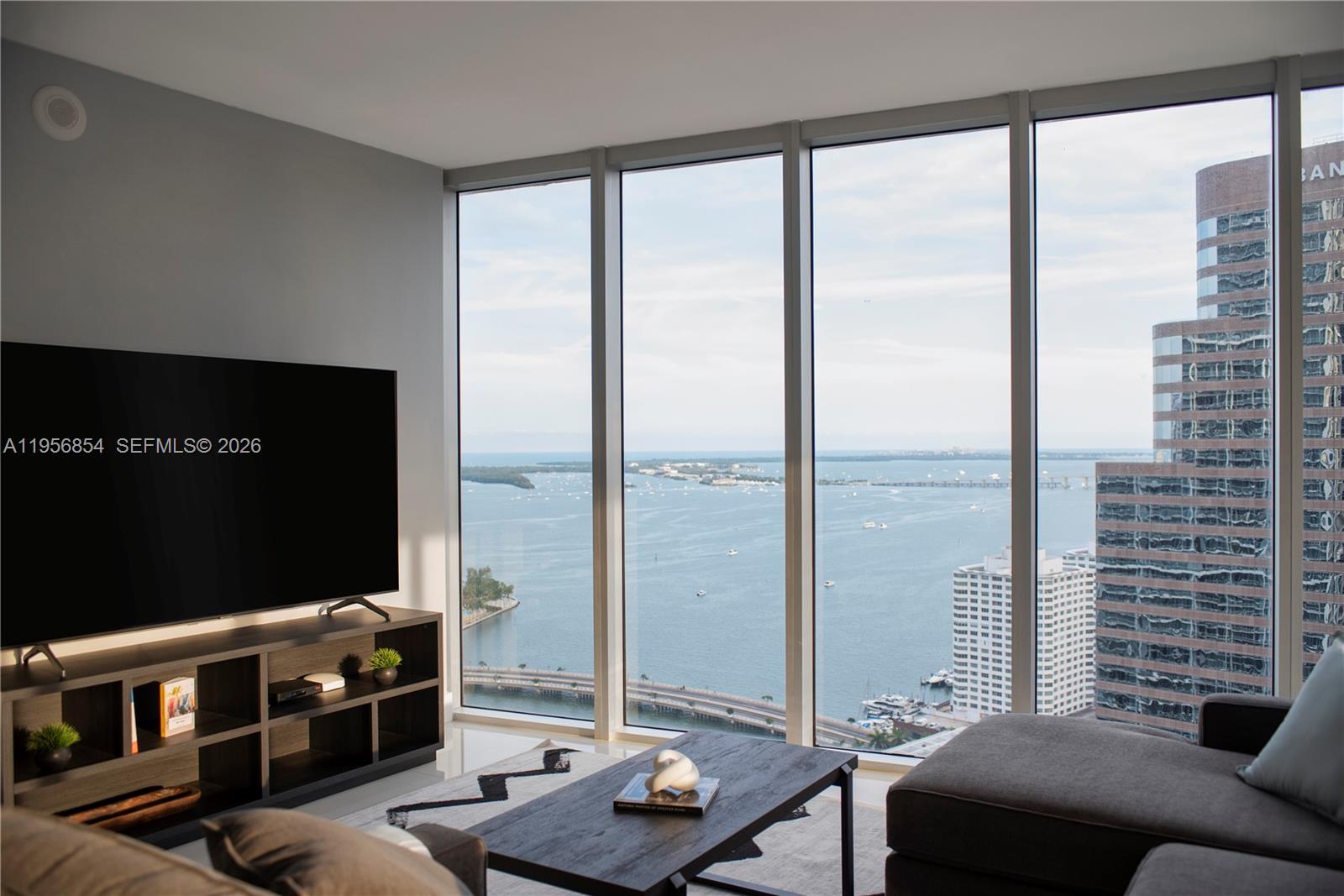 In the heart of Brickell’s waterfront district, steps from Brickell City Centre and Mary Brickell Village. ICON Brickell Tower 3 is a Philippe Starck-designed, full-service condo-hotel on the Biscayne Bay/Miami River with resort-style amenities including a 300-ft pool, spa & 28,000 SF fitness center. Ideal as a primary residence, second home, or flexible income property with short-term rental options. Residence 3208 is a bright corner home with floor-to-ceiling glass framing Biscayne Bay and skyline views, plus a private balcony. Open living and dining flow to the view. Modern kitchen features warm wood cabinetry, sleek black countertops, panel-ready refrigerator, and built-in microwave/oven. Spacious bedroom with bay views. Spa-style bath with double vessel sinks, soaking tub, and glass-enclosed shower.