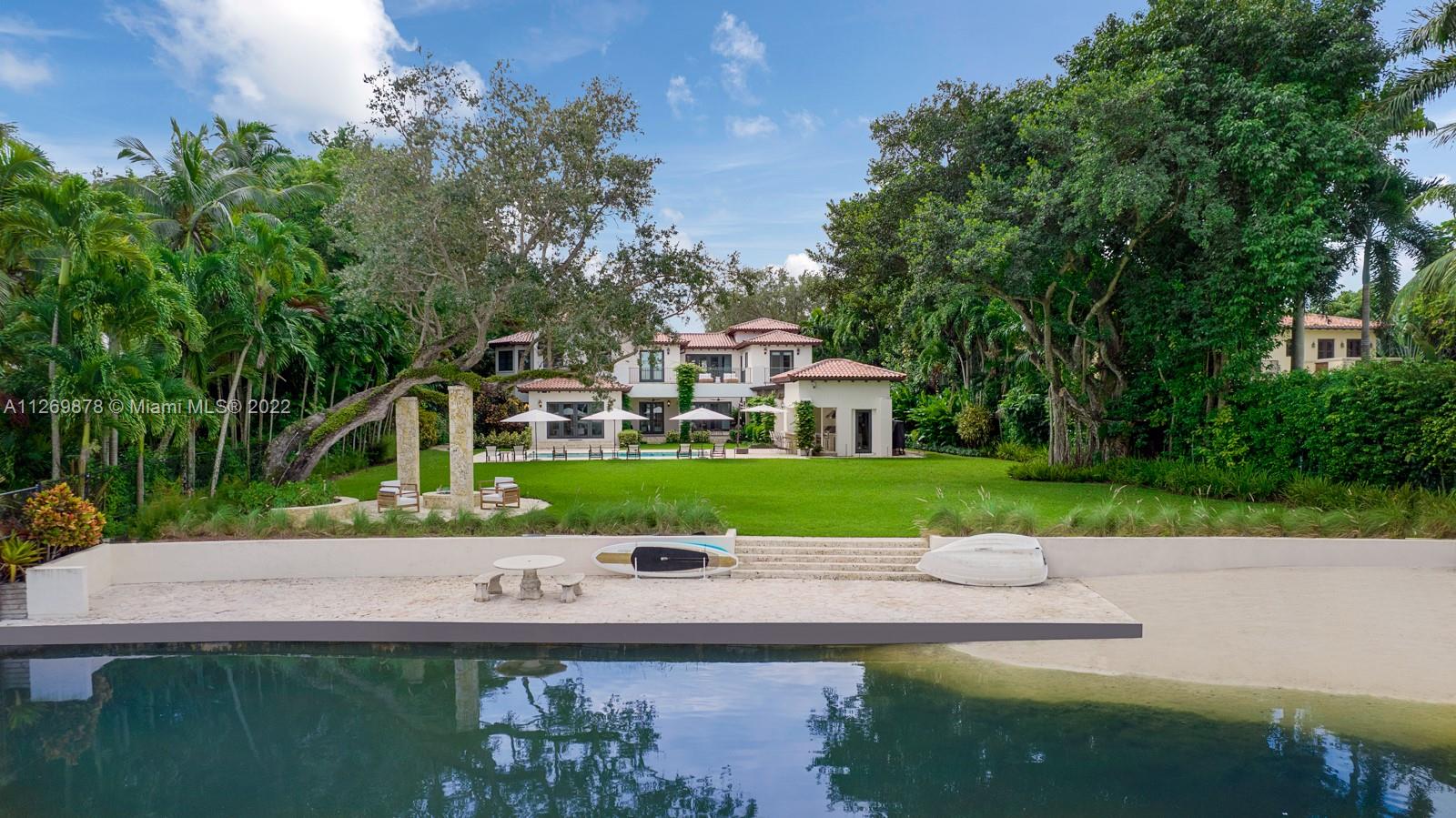 Spectacular 9,482 Sq.Ft. estate with 6 bedrooms and 7.5 baths, on nearly an acre in the guard-gated community of Hammock Lakes. The home has a new roof and an air-conditioned 3-car garage with a gym. Stunning lake views, lush landscaping, arched hallways and vine-covered porticoes. Elegant light-filled living spaces with high ceilings, 2 family rooms, 2 offices and bar. Chef's kitchen with marble center island, wood cabinetry and stainless steel Viking and Miele appliances. The main suite has 2 custom walk-in closets and a spa-like bathroom with double vanities, expansive shower and commodious bathtub. Outdoors have covered terraces ideal for relaxing, barbecue area, pool, fire pit, half basketball court and sandy beach. Resort-style living in an enchanting setting.
