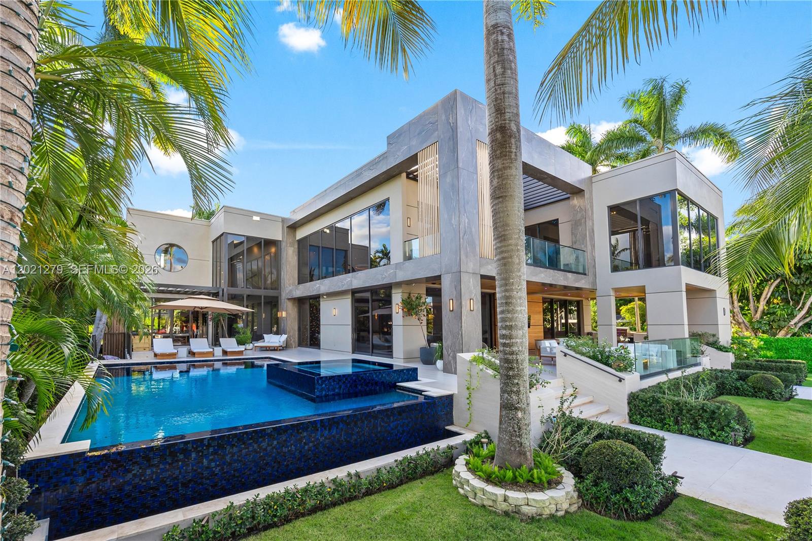 Villa Miradar is a rare modern waterfront estate in the exclusive doubled-gated enclave of Belle Meade Island. Spanning over 10,000 SF on a 16,500 SF lot with 100 feet of water frontage and direct open bay access, the residence captures a refined balance of architecture, wellness and effortless Miami waterfront living. The estate is developed by Nouri Group, with natural light pouring through walls of disappearing glass, fully opening the home to the water and tropical landscape. Finishes of travertine, marble, wood, stone and soft cement create a warm yet elevated palette that feels both modern and timeless. The estate features 7 bedrooms and 8.5 bathrooms, including a serene primary suite and generous guest accommodations. Curated wellness and entertainment spaces include a private movie theater, state-of-the-art fitness studio, and spa-inspired hammam, alongside a sauna and cold plunge. A private office, elevator, chef's kitchen with butler's kitchen, expansive living and dining areas and fully integrated smart home system complete the residence with effortless sophistication. Outdoors, an infinity-edge pool, waterfront lounges and expansive terraces create a resort-like setting with uninterrupted water views, designed for both relaxation and elevated entertaining. Moments from the Design District, Bal Harbour Shops and Miami's finest cultural and dining destinations, Villa Miradar is a modern waterfront estate defined by art, wellness, privacy and architectural presence.