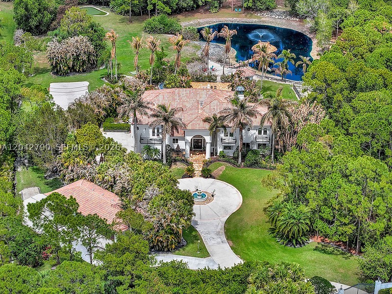 This is not your typical luxury listing. The estate sits on 5+ acres with a collection of amenities that are rarely found together in a residential setting. Located in Ranch Colony, an exclusive, 24 hour guarded/gated, community comprised of five subdivisions which include two premier 18-hole golf courses, an aviation airpark, and luxury equestrian estates sprinkled throughout. The residence is surrounded by beautifully landscaped grounds that offer a resort-like setting, featuring a par-3 golf hole with driving range, a small lake with sandy beach and  50-ft dock, a sand volleyball court, and an incredible outdoor living area anchored by an extensive screened patio, 50-ft swimming pool, tiki hut and waterfront lounge. For car lovers, the estate also features a climate-controlled six-bay fully finished garage with separate open parking pad with RV Power, as well as a 3.5-car attached garage, and a gated, circular driveway with water fountain. Inside, the home is equally impressive, designed for both entertaining and everyday comfort, with expansive living areas, new gourmet kitchen showcases Cristallo stone countertops with under-lit surfaces, Sub-Zero appliances, and a beamed ceiling. The primary bath and three additional bathrooms have been completely remodeled with modern contemporary elegance and spa-like comfort. Custom impact windows and doors.  A unique lifestyle-driven layout that appeals to high-net-worth buyers seeking privacy and recreation at home.