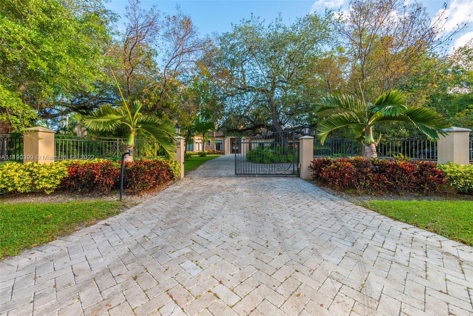 North Pinecrest One Story, Contemporary Villa on over One Acre surrounded by lush landscaping and nested with mature live oaks. Imposing entry and living room with 25' soaring ceilings. Luxurious use of high end finishes and materials. LaFinestra impact windows and doors, plenty of natural light, motorized blackout blinds and curtains in all rooms. Gourmet chef's dream kitchen with Wolf/Miele appliances, two professional ovens (electrical and gas). Bedrooms offer Bathrooms in-suite with granite slab baths, large closets, spectacular outdoor luxury yard with resort style heated pool and spa, tanning ledge. Detached Summer kitchen offers built in BBQ and bar areas perfect for entertaining. Smart system control pools light and temp. Wall and gated!