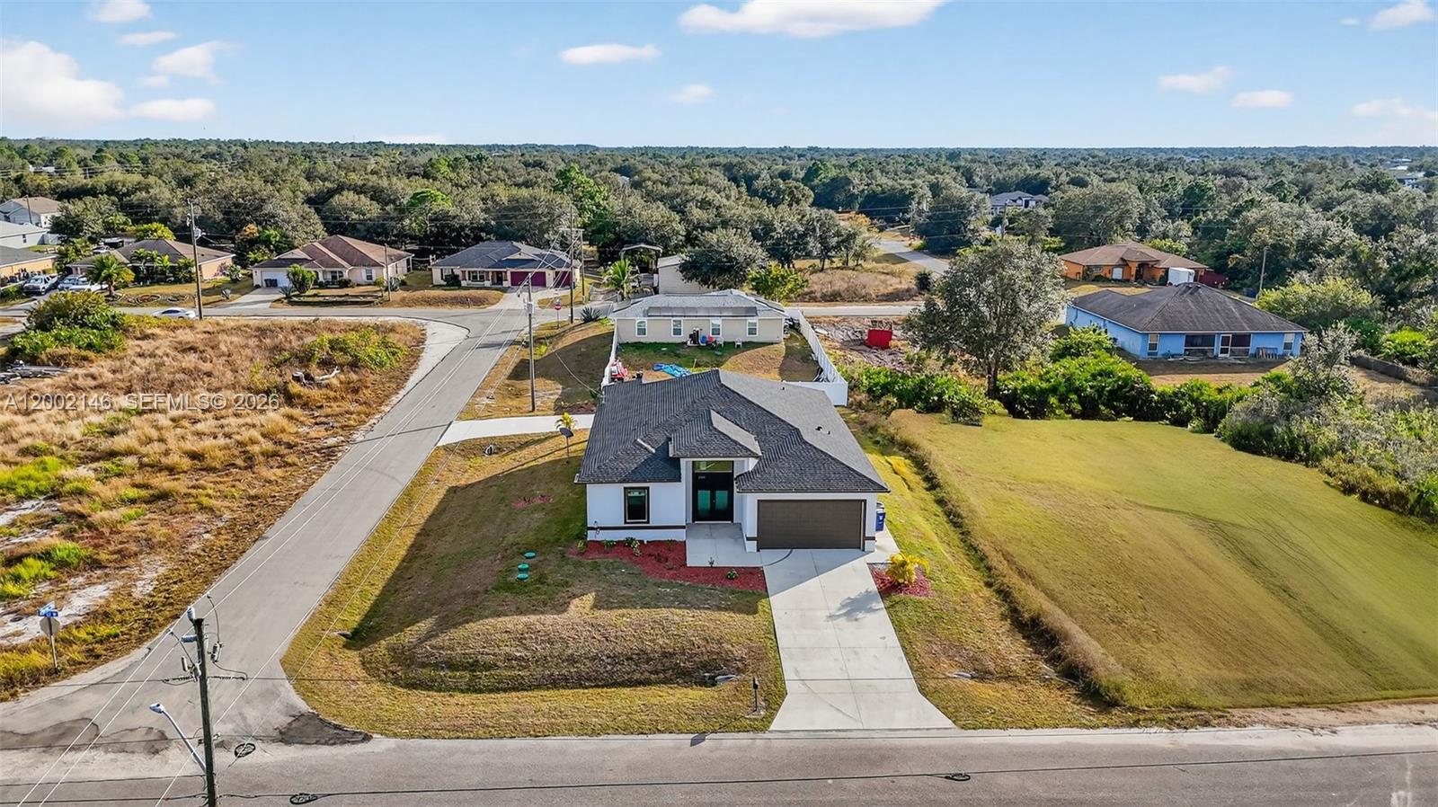 Built in 2024 by a private builder, this newer construction home sits on a spacious corner lot in Lehigh Acres and features a custom-designed layout that stands apart from typical builder-grade homes. Offering 2,161 sq ft under air and 2,591 total sq ft, this home is larger than many properties in the area, providing plenty of room to live, work, and entertain comfortably. This 4-bedroom residence includes multiple en-suite style bedrooms, creating ideal separation for guests, extended living, or shared households. Bright open-concept design with high ceilings, tile flooring throughout, and abundant natural light. The kitchen is centrally positioned with a large island, modern cabinetry, quartz countertops, and stainless steel appliances. The primary suite offers a spacious bath with upgraded finishes and a functional layout. Additional highlights include impact windows and doors, covered rear patio, 2-car garage, and dual driveways offering ample parking for multiple vehicles, work trucks, or recreational vehicles. No HOA. Conveniently located near major roads, shopping, dining, and schools. Property is also available for rent, offering flexibility for end users or investors.