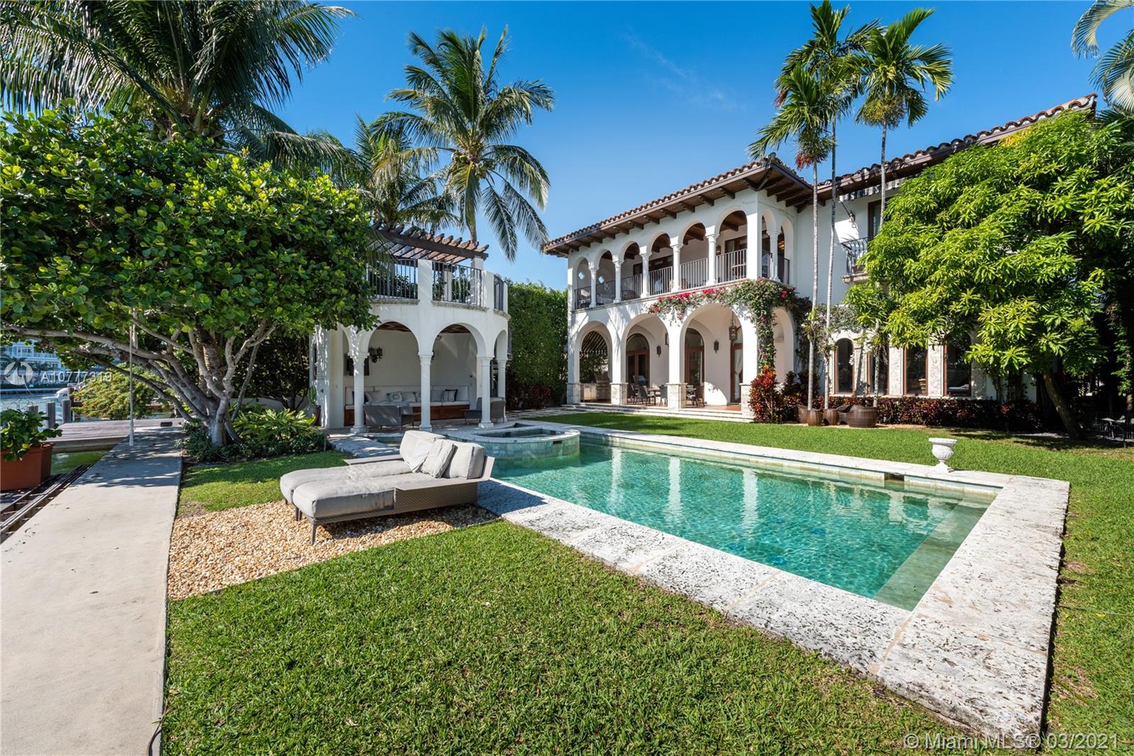 Grand Mediterranean waterfront home on Surprise Lake in Miami Beach with 70 feet of waterfront, offering southern exposure & open water views. Built in 2007, the home features soaring 12-foot ceilings with intricate wood & plaster design, dramatically oversized arched doorways & windows, & many other beautiful details. First floor offers large living room, great room, formal dining, chef’s kitchen, entertainment bar & wine cellar. Second floor offers waterfront master suite with huge walk-in closets & bath with a steam shower, & 3 bedrooms with en-suite closets & baths. Detached guesthouse with 2 guest studio rooms equipped with baths & kitchenette is connected to the main house with covered loggia. Large 14,410-SF lot, lush landscape, beautiful courtyards, 4-car garage.