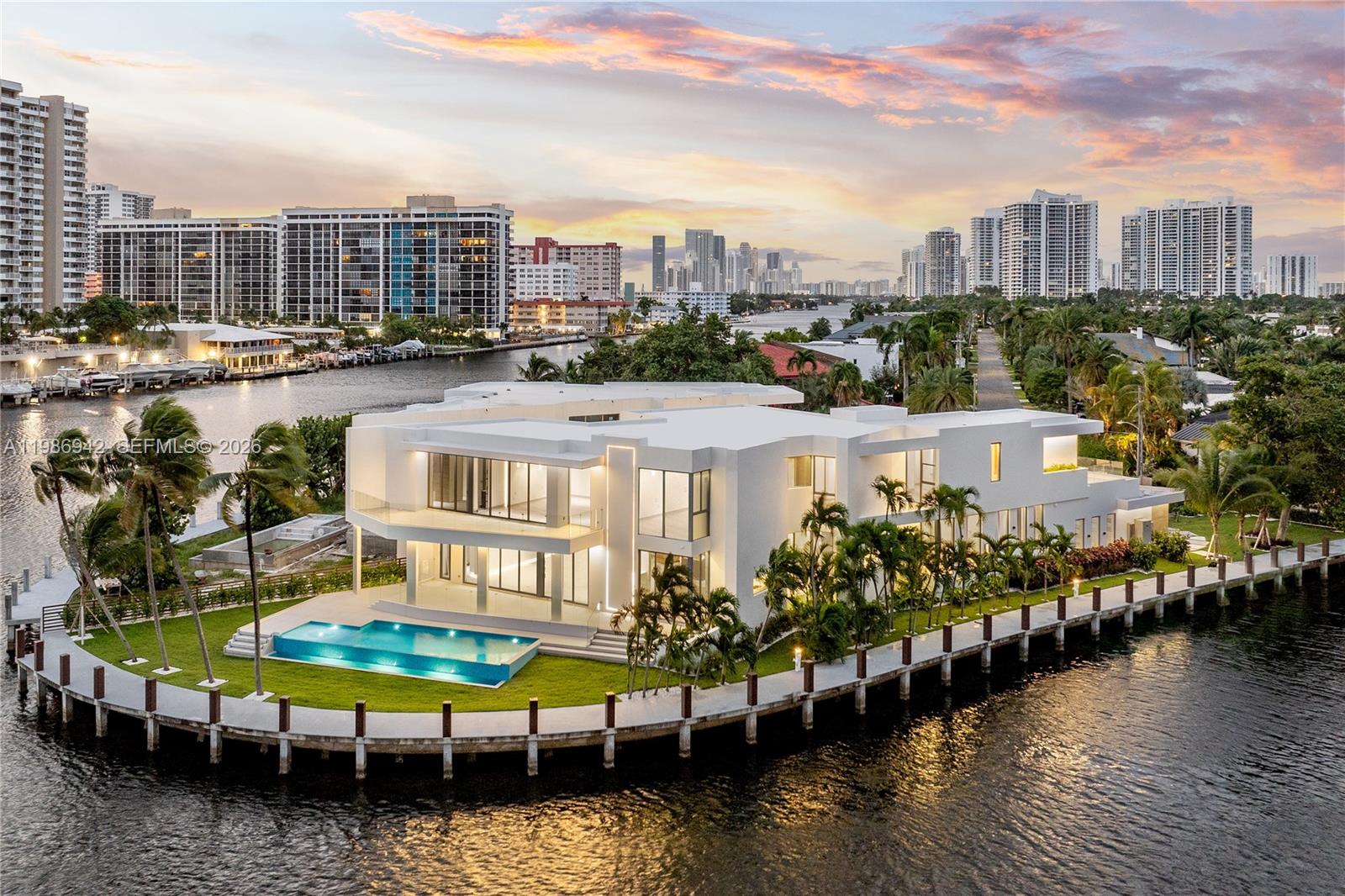 Nestled within the exclusive guard-gated waterfront enclave of Golden Isles in Hallandale Beach, this residence is a true statement of architectural excellence. Positioned on a 16,000 SF point lot along the Intracoastal Waterway, this exceptional estate offers the ability to accommodate a 200 FT mega yacht. Spanning 8,000 SF of meticulously designed interiors, the home features seven bedrooms—five upstairs and two on the main level—plus a private office and fully equipped gym, all crafted with premium materials and custom millwork throughout.The expansive 1,400 SF primary suite offers ultimate privacy with separate his-and-hers bathrooms and custom closets. Additional highlights include a designer European kitchen, wet bar, wine cellar, elevator, and media room. Outdoors, enjoy 315 feet of water frontage, a brand new concrete dock, no fixed bridges, and a resort-style pool with summer kitchen—perfect for true waterfront living and entertaining. Golden Isles is perfectly positioned between Fort Lauderdale and Miami Beach, offering the best of both worlds with unmatched value. Close to A+ schools, Aventura Mall, Bal Harbour shoppes  and just 15 minutes to the open ocean.