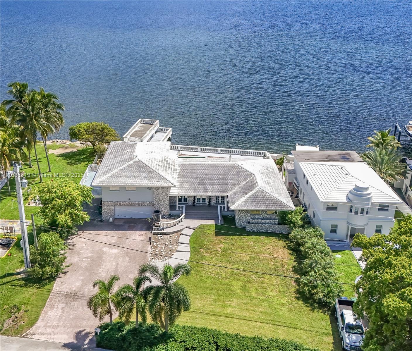 RARE BAYFRONT DEVELOPMENT OPPORTUNITY – 102 FEET ON WIDE OPEN BAY! Incredible chance to build new on a 12,765 SF lot (102x125) with panoramic bay views just 7 miles north of Downtown Miami. Surrounded by new construction in a rapidly transforming neighborhood, this oversized waterfront parcel features a solid concrete seawall, expansive dock, and large concrete deck — perfect for luxury waterfront development. The existing 5-bed, 6-bath home (5,000 SF under roof / 3,200 SF under A/C) can be remodeled or removed to make way for a custom estate. Few properties offer this scale, frontage, and open bay exposure — ideal for developers or end-users looking to create a trophy home.