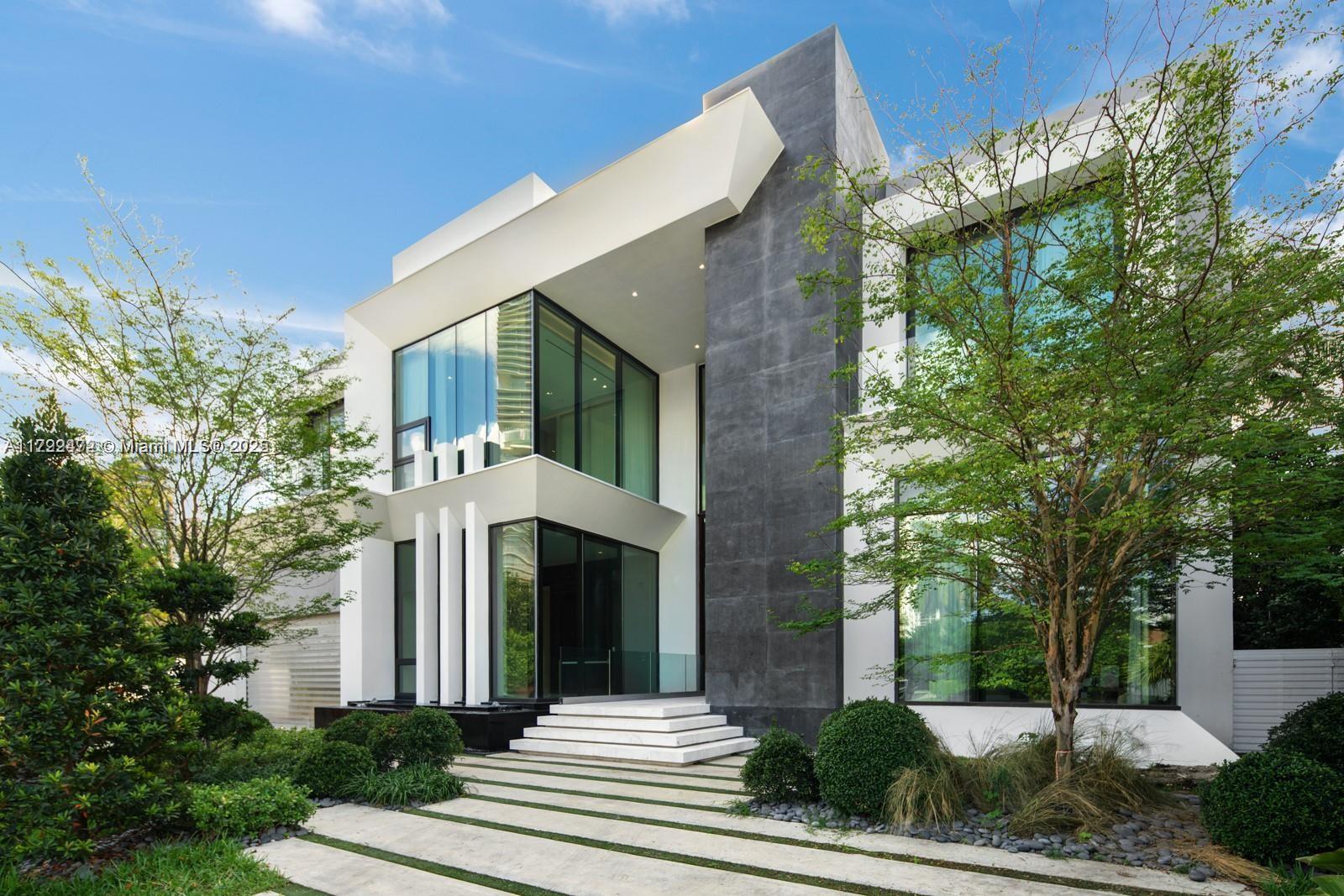 This contemporary waterfront residence, a collaboration between architect Danny Sorogon and interior designer Steven G, showcases bespoke architectural details that enhance its comfort and opulence. Crafted with precision, the home boasts a glass-box elevator, a custom floating staircase, sculptural walls cleverly concealing hidden doorways, and exquisite stonework finishes, creating a truly unique design. Luxurious amenities, including a Veneta Cucina chef’s kitchen with Wolf and Subzero appliances, 27-foot ceilings and expansive glass walls offering stunning Intracoastal Waterway views. A new dock for your showpiece yacht, and indulge in the resort-style pool, spa, summer kitchen, and an oversized rooftop terrace and games deck. Live grandly in this masterfully designed family residence.