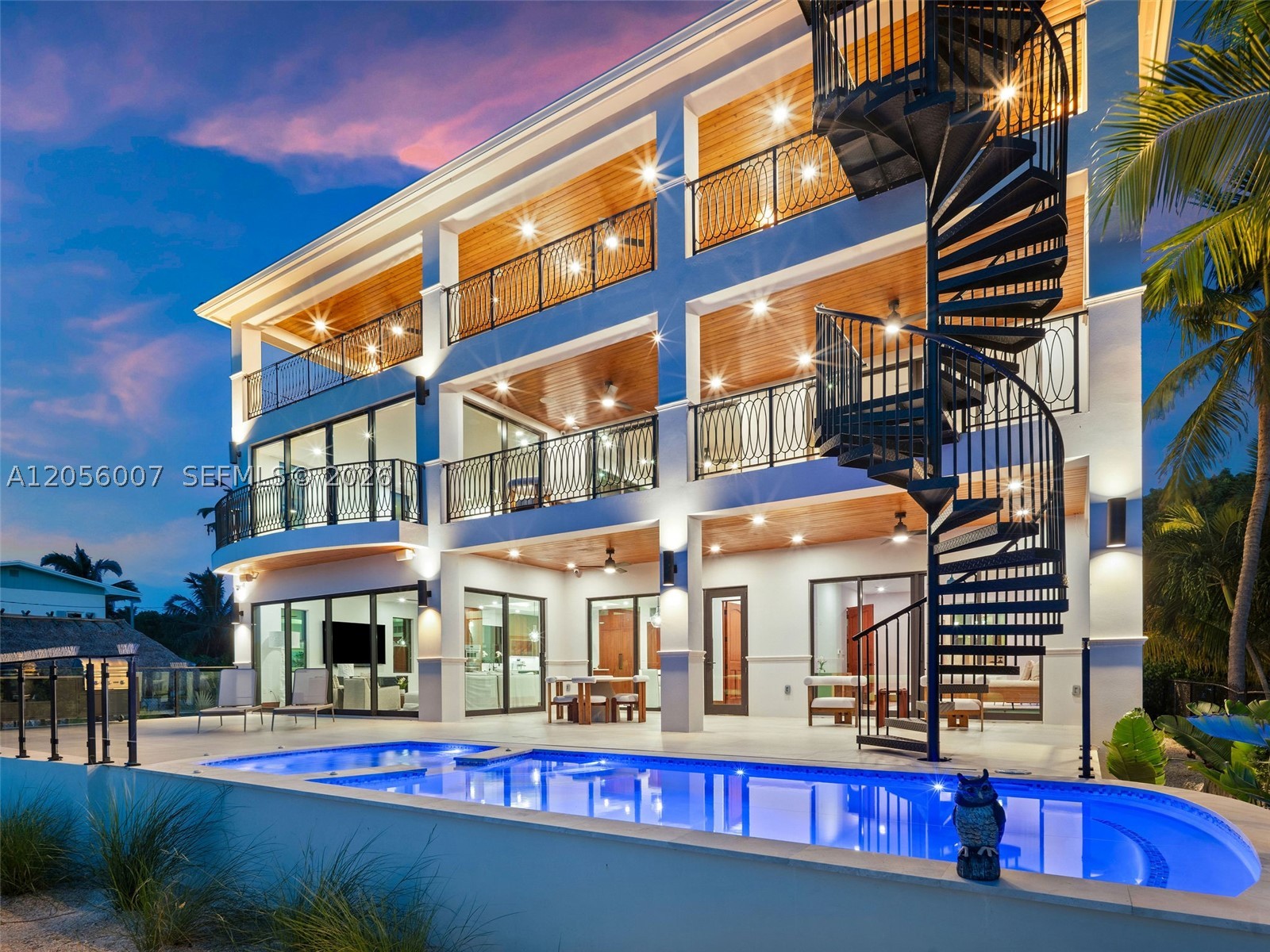 Sunset Sanctuary. Natural beauty and captivating sunsets of the Florida Keys define this newly completed gated waterfront estate on Lower Matecumbe Key. Surrounded by a serene coastal landscape and native birdlife, the property offers boating access to both Florida Bay and the Atlantic Ocean. Completed in 2025, the three-level main residence features two primary suites, three guest bedroom suites, media room, an elevator, and a custom kitchen showcasing mahogany cabinetry and Thermador appliances. Expansive balconies extend the living spaces into the natural surroundings. The third-level Sunset Lounge elevates entertaining with a full bar, wine storage, generous seating, a mega-TV, and views toward Florida Bay. Outdoors, the property features a saltwater pool and spa, covered dining and entertaining areas, a private pickleball court, and a dock with boat lift. A detached guest house provides comfortable accommodations with added separation from the main residence. This distinctive Islamorada estate brings together natural beauty, recreation, boating access, and elevated island living.