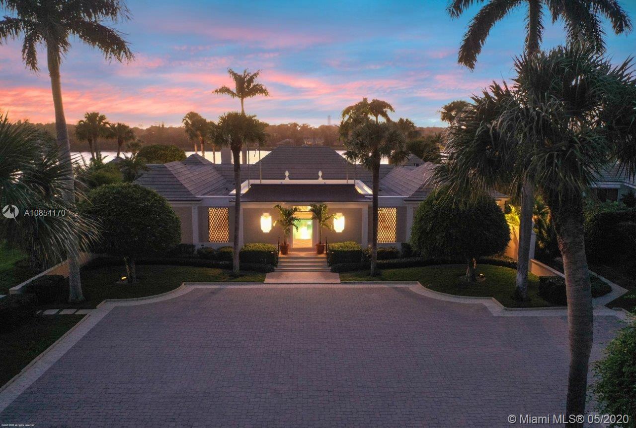 Nestled along the Intracoastal Waterway, with a total of 6-bedrooms, this courtyard-style residence offers peace and tranquility throughout its over 5,200 square feet of elegant living spaces. Impeccably maintained with sophisticated style featuring fine craftsmanship, tray ceilings and terrazzo floors. The main house surrounds a covered patio with heated pool and includes 2 bedrooms in each wing connected by a spacious living room. Flanking the living room is a formal dining room and an inviting family room/den with fireplace. The master suite is situated to take in panoramic views to the west and south. Over 2 lush acres with beautiful landscaping and a vast lawn that sweeps down to 217± of protected shoreline. 2-bedroom guesthouse and a 2-car garage with ample storage for 2 golf carts.