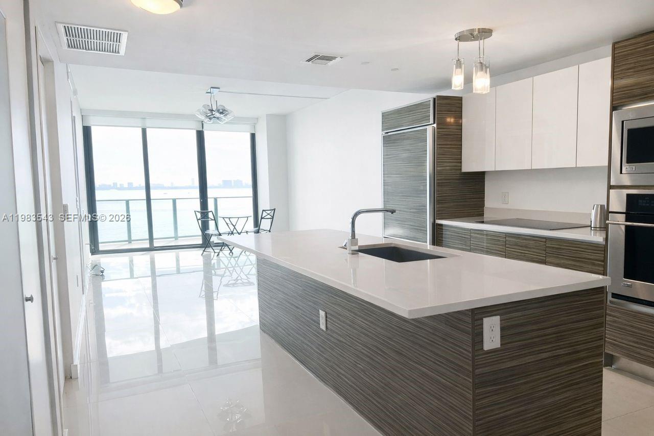 Experience the pinnacle of Edgewater luxury in this designer-inspired, 2-bedroom, 2-bathroom sanctuary perched on the 14th floor of the prestigious Icon Bay. Spanning 1,095 square feet of sleek living space, this residence features a private foyer, Italian porcelain floors, custom closets, and designer lighting throughout. Floor-to-ceiling windows flood the open-concept layout with natural light, showcasing breathtaking, direct panoramic views of Biscayne Bay from every room and your private balcony. The primary suite serves as a refined retreat with an en-suite bath and high-end window treatments. Residents enjoy five-star, resort-style amenities, including an infinity-edge bayfront pool, state-of-the-art fitness center, spa, tennis courts, theater room, and a private waterfront park with curated art installations. Strategically located just minutes from the Design District, Wynwood, and Midtown, with Whole Foods and elite dining just around the corner. Unit includes one assigned parking space, 24/7 concierge, and valet service.
