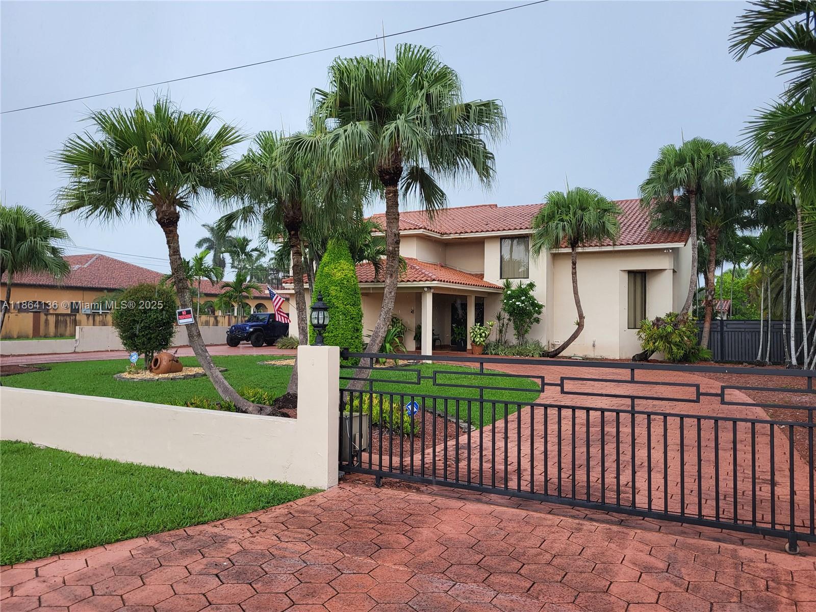 Beautiful two-story home with porte cache on a 30,492-sf estate. This home features a pool bathroom, outdoor gazebo and kitchenette/bar. The main house offers 4 beds 4 baths, formal living, dining room, gourmet kitchen, wet bar, and two family rooms. Wood Cabinets, Granite Tops, Stainless Appliances and also wide Staircase. Plenty of Closet space. Lots of potential to make it your own. Resort Style and Amenities. The Master Suite boasts a spacious layout with a sitting area, terrace, walk-in closets, and a luxurious spa-like bath.  Outdoor oasis includes a large pool, and gazebo. Additional highlights: Impact Windows, Gated Property, Remote controlled Gates, 2-Car Garage, Beautiful Palm trees, Avocado tree, Lime tree and a Generous Yard .