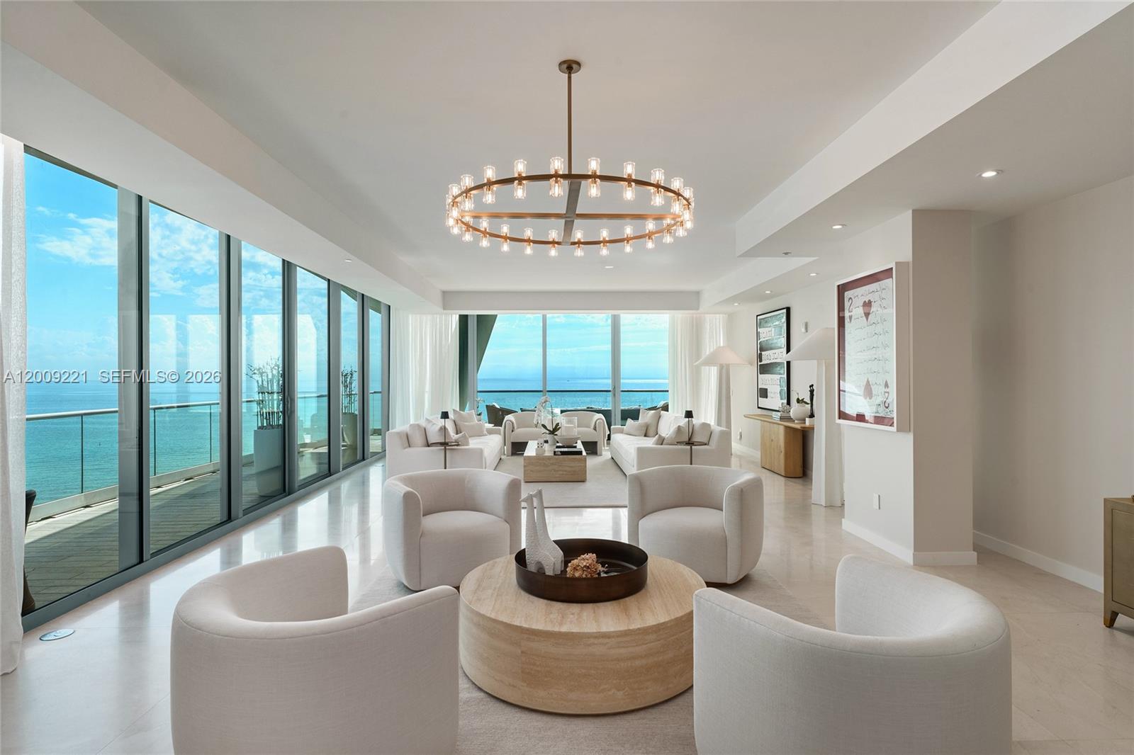Hear the ocean waves from this direct oceanfront corner unit at Fendi Château Residences. This exceptional 3BR + media room (easily convertible to a 4th BR) offers 5 full bathrooms plus a powder room, spanning 4,487 SF with exquisite large-slab stone floors throughout. Private elevator entry opens to an elegant foyer and expansive living area surrounded by walls of glass, filling the space with natural light and leading to a 1,599 SF wraparound terrace with unobstructed ocean and city views. Designed for true indoor-outdoor living, the terrace features a hidden summer kitchen, multiple lounge areas, and breathtaking sunrise-to-sunset views from the Atlantic Ocean to the city skyline. The sleek Mia Cucina–designed chef’s kitchen features a large granite eat-in island, top-tier Gaggenau appliances, Sub-Zero refrigeration, and dual wine chillers, plus a separate breakfast area. An open dining area with a custom chandelier sits adjacent. The spacious family/media room is accessed behind a custom millwork wall with a discreet hidden door and can be easily converted into a 4th bedroom. The sumptuous principal suite boasts a custom designer walk-in closet, direct ocean terrace access, and dual spa-inspired bathrooms. Two additional west-facing bedrooms feature en-suite baths and terrace access with city views. Additional highlights include a Sonos system, blackout shades in all bedrooms, and a laundry room with a full bathroom. 5-star Fendi amenities complete this amazing offering.