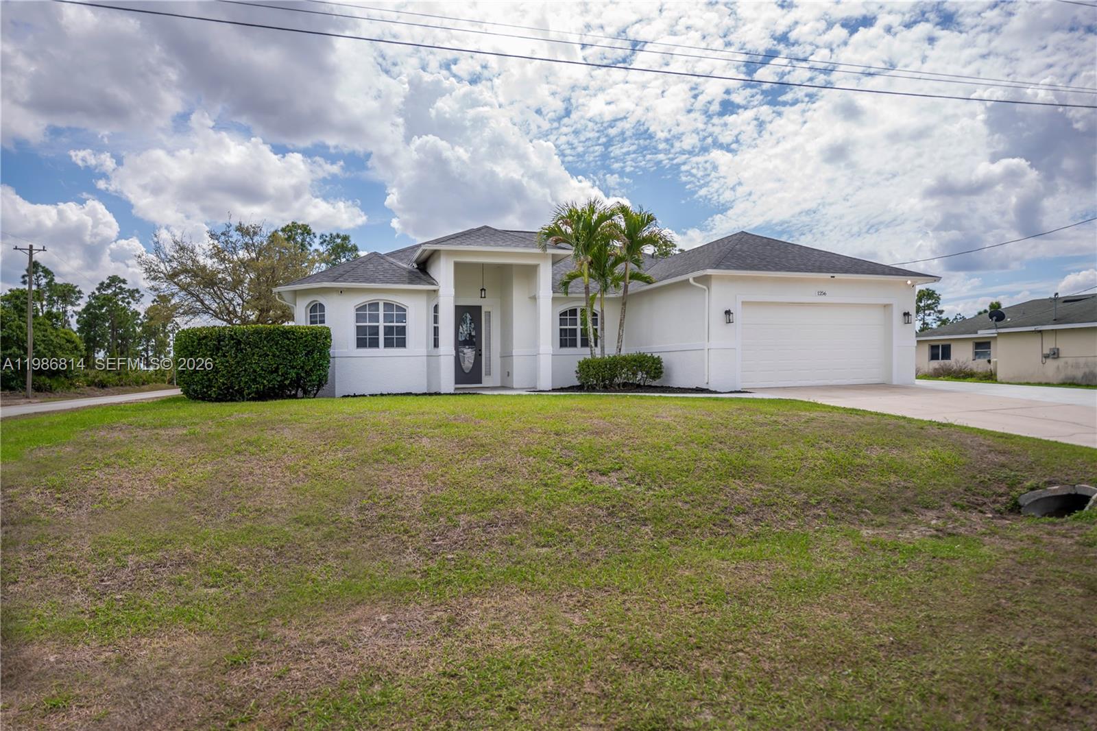 Welcome to this exceptional 4-bedroom, 2-bathroom home on a spacious, oversized corner lot.   Designer touches include vaulted ceilings, contemporary lighting fixtures and accent walls as well as a stately front entryway and foyer.  The spacious kitchen which features a substantial island, a stainless-steel appliance package, quartz countertops and abundant cabinet space. The generous primary suite provides a true retreat, a relaxing jacuzzi tub and an oversized walk-in shower.  A designated laundry room also provides additional storage capabilities as does the attached 2-car garage. 
Step outside offering endless possibilities for outdoor living, entertaining, or creating your dream garden oasis. while the well-maintained landscaping, sprinkler system, and fresh exterior paint create outstanding curb appeal. Families will also appreciate access to a variety of highly regarded public and private schools within Lee County.  This meticulously maintained home also has impact resistant windows and delivers peace of mind with numerous recent upgrades, including: * New shingle roof (2023) * New water heater (2024) * Water system (2018) with softener replaced in December 2025 * AC system (2019) with compressor replaced in March 2025 Move-in ready and full of value, this home is a must-see!