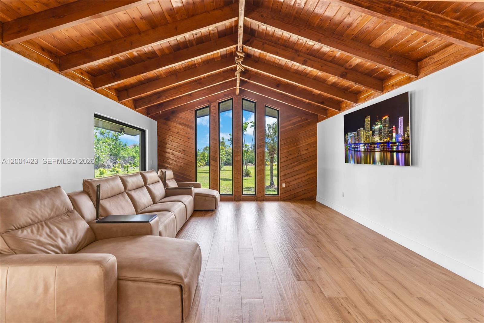 This beautifully remodeled 4 bedroom, 2 bathroom residence offers a rare blend of architectural character, modern upgrades, and expansive outdoor living. From the moment you arrive, the property sets a distingueshed tone with its clean, modern lines. Inside, a bright open layout is enhanced by elegant Italian tile flooring and incredible natural light. The main living area features soaring vaulted wood ceilings and dramatic floor to ceiling windows, creating a warm yet sophisticated space ideal for both everyday living and entertaining. At the heart of the home, a stunning glass enclosed interior garden courtyard creates a true architectural statement, bringing natural elements indoors and serving as a tranquil focal point that seamlessly connects multiple living spaces. The chef’s kitchen showcases sleek cabinetry, stainless steel appliances, and quartz countertops with a waterfall edge island. Completely renovated in 2024, no expense spared in this meticulous renovation, showcasing top of the line materials, the home includes new plumbing, electrical, roof, A/C, & so much more, along with commercial grade impact windows and doors. The property offers over 50 fruit trees, expansive grounds with room to create your own ideal outdoor setting, like a pool or outdoor kitchen, the possibilities are unless. A covered boat/RV shelter with electricity. Ideally located just minutes from the Florida Turnpike, shopping and dining options, less than 5 miles from Black Point Marina, offering direct access to Biscayne Bay for boating and waterfront dining.