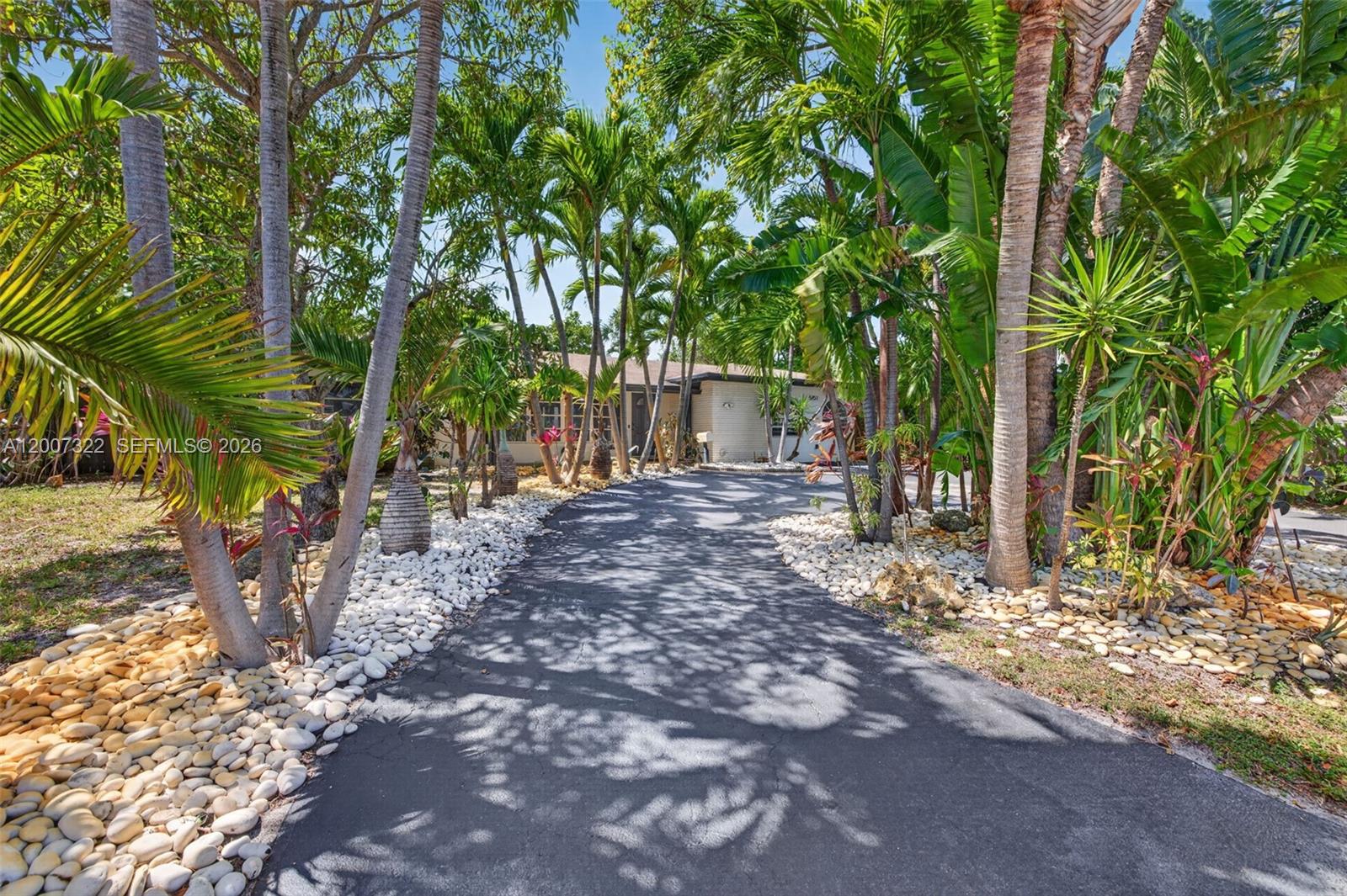In the heart of Knoll Ridge, this 4 bedroom, 2 bath home offers a rare blend of space, flexibility, and freedom with no HOA. With over 2,100 sq ft, the layout is open and functional, featuring ceramic flooring throughout, generously sized bedrooms, and two primary-style bathrooms designed for comfort and privacy. Set on an oversized, newly landscaped lot, the outdoor space truly stands out. A circular driveway offers ample parking with room for a boat or RV, while the backyard unfolds into a private tropical retreat with a sparkling pool refinished in 2022, a shaded pagoda, and mature fruit trees that create a relaxed, resort-style setting. Whether you're looking for a full-time residence, a second home, or an Airbnb-ready investment, the possibilities here are wide open. Ideally located just one mile to the beach and minutes from top-rated schools, dining, shopping, major highways, and the airport, this is a rare opportunity to secure space, location, and lifestyle all in one.