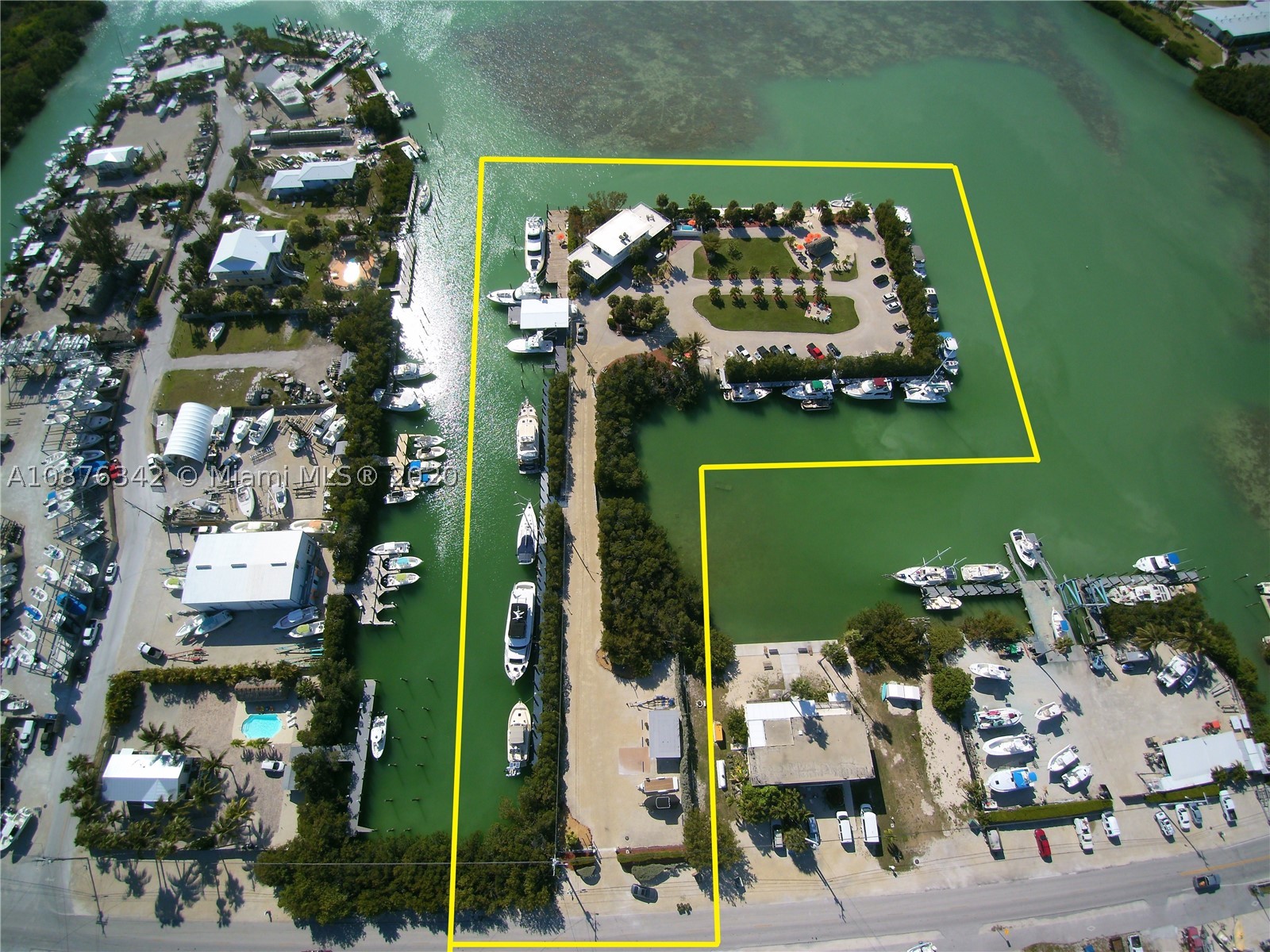 Wow! This is a private Island Oasis in Marathon, on Bonefish Bay. First time offered for sale in 25 years. The island has 1.75 Acres w/ approx. 1,200 lineal ft of deep draft boat dockage. 27 wet slips permitted, each with electric meter. Can accommodate up to 110' yachts. Also has boat ramp. Gorgeous 4,500 sf. single family waterfront 3bd/2.5 ba home is solid CBS/concrete slab & ceiling construction w/ Generator. 2 market rate RES units recognized. 3 Buildings, Men's/Women's shower room & Storage building. AE Flood Zone. Partial Baybottom owned & other leased from State. Connected to CoCoPlum Dr. with private gated entrance & 30+ parking spaces. Zoning is MU, Mixed Use allows for many commercial uses incl. Multi Unit Residential, Yacht Club & Marina, Boat storage & racks, and much more