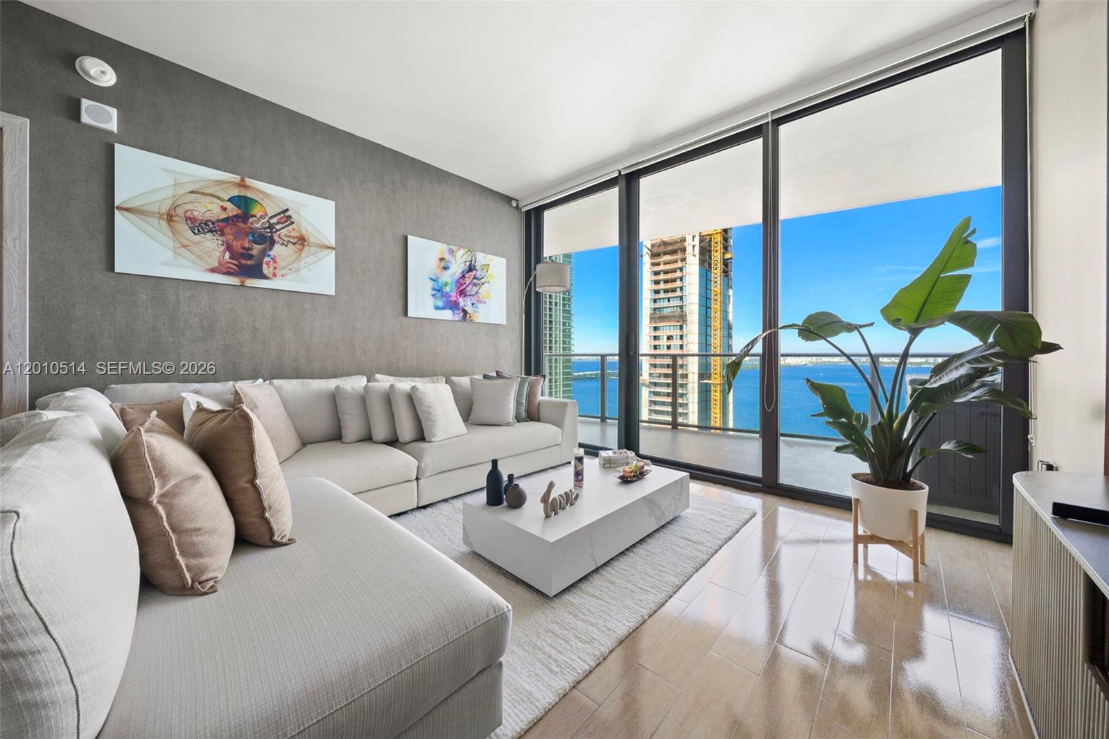Experience elevated waterfront living at Icon Bay in this beautifully upgraded 2 Bed + Den / 2 Bath residence in the heart of Edgewater. Enter through your private elevator foyer into a light-filled, open-concept layout featuring upgraded flooring throughout and floor-to-ceiling impact windows showcasing stunning Biscayne Bay views. This residence has been thoughtfully enhanced with designer upgrades, including fully renovated baths with new vanities, complemented by sleek LED mirrors for a modern, spa-like feel. The primary suite features high-end tile work in the shower, elevating it beyond standard developer finishes.Additional highlights include elegant wall treatments, upgraded interior doors and frames, motorized shades, and multiple custom built-ins providing both style and functional storage. The spacious kitchen flows seamlessly into the living and dining areas, while the expansive private balcony—accessible from both the living room and primary bedroom—offers the perfect setting for indoor-outdoor living. Icon Bay residents enjoy resort-style amenities including a bayfront pool, state-of-the-art fitness center, clubroom, theater, tennis and basketball courts, as well as 24-hour concierge, valet, and security. Ideally located just minutes from the Miami Design District, Wynwood, Midtown, Miami Beach, and MIA airport, this home offers the perfect balance of luxury, convenience, and lifestyle.