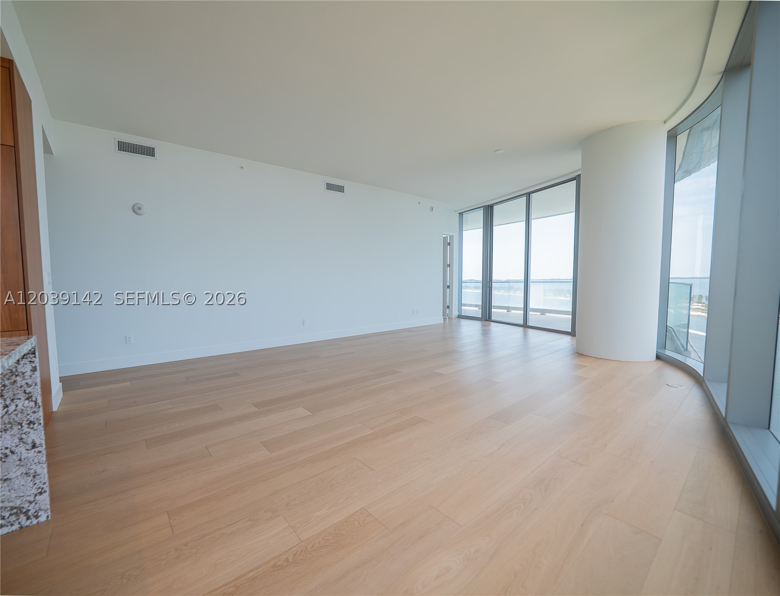 The most desirable corner line in the building, with open, unobstructed water views reaching the horizon and exposures toward Coconut Grove, Coral Gables and Key Biscayne. Tucked into an exclusive waterfront pocket south of Brickell, UNA keeps just 135 residences — rare privacy and scale paired with full-service luxury. This 3BR/3.5BA home spans 2,115 SF interior plus 312 SF of terrace, with 10'8" floor-to-ceiling glass, wood flooring throughout and a Gaggenau-equipped kitchen. Amenities run resort-deep: three pools, full-service spa, fitness center, private screening room, children's playground and complimentary luxury transportation within a 7-mile radius — a benchmark for boutique bayfront living.