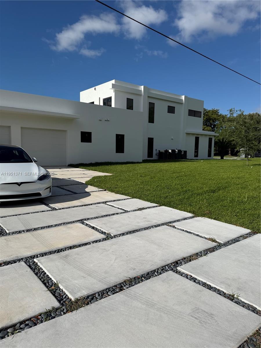 A rare opportunity to own a newly completed modern estate in the heart of prestigious Pinecrest. Set on a quiet, tree-lined street, this architectural masterpiece blends bold contemporary design with refined luxury and exceptional craftsmanship. Walking above the reflection pond entrance feature, taking in the striking façade and through the dramatic solid-wood pivot door into the grand double-height entry, the home makes an immediate impression. Walls of glass flood the interiors with natural light and create a seamless connection between expansive living spaces and the outdoors—ideal for both everyday living and elegant entertaining. The residence offers eight spacious bedroom suites, each with a private spa-inspired bath. The primary suite is a true retreat with a lavish bathroom, oversized custom closets, huge balcony and serene views. The chef’s kitchen is a showpiece, featuring brand new appliances, custom cabinetry, an oversized island, and walk-in pantry, opening to sophisticated family and dining areas. Designed for indoor-outdoor living, the resort-style backyard features a stunning resort style pool with swim-up bar and spa, a concrete gazebo with summer kitchen, and lush landscaping—your own private oasis. Additional highlights include a dramatic skeleton staircase, media room, huge laundry, service quarters and a multi-car garage. Minutes from top-rated schools and parks, this is not just a home—it is a statement.